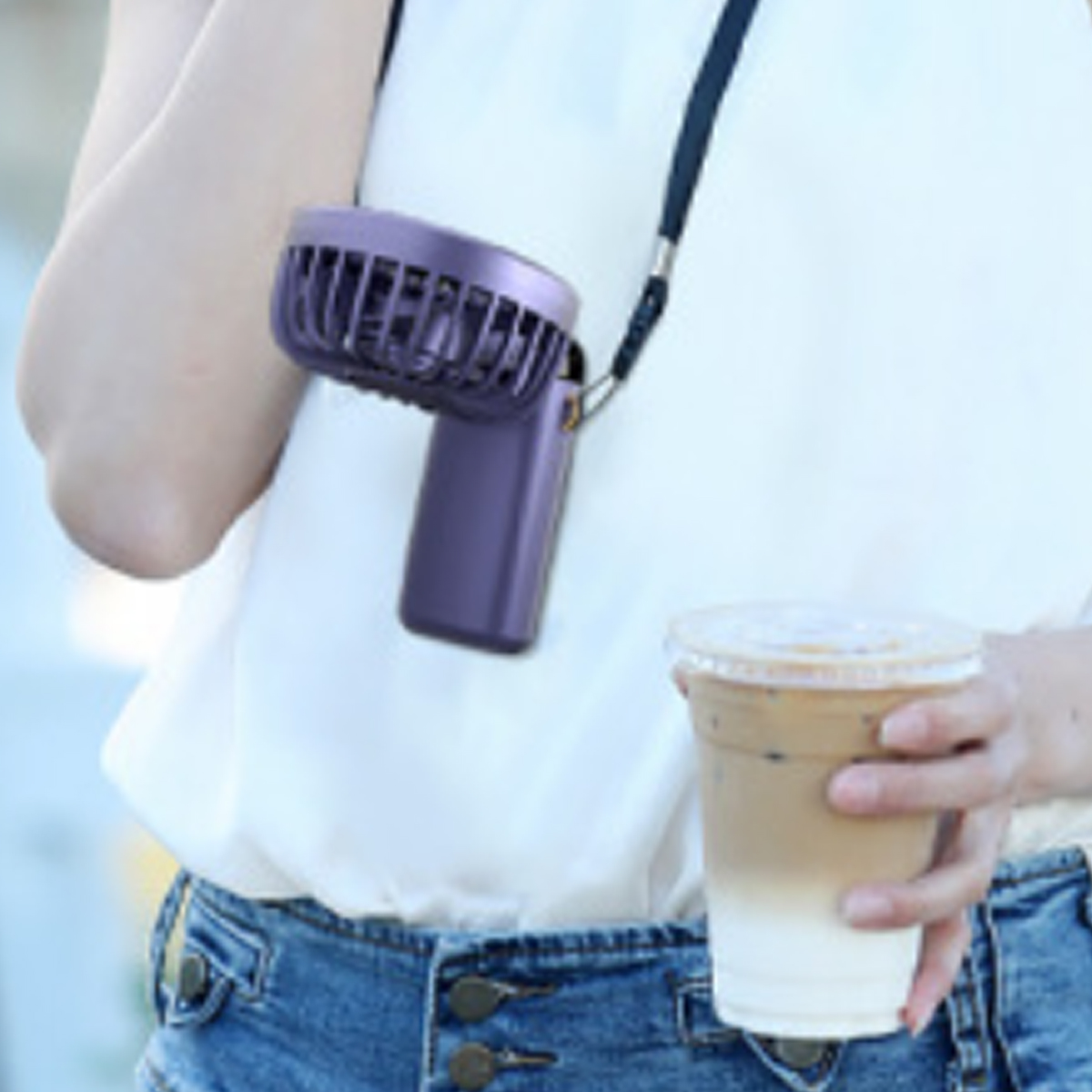 Eine Person mit einem Halsventilator und einem Kaffeebecher.