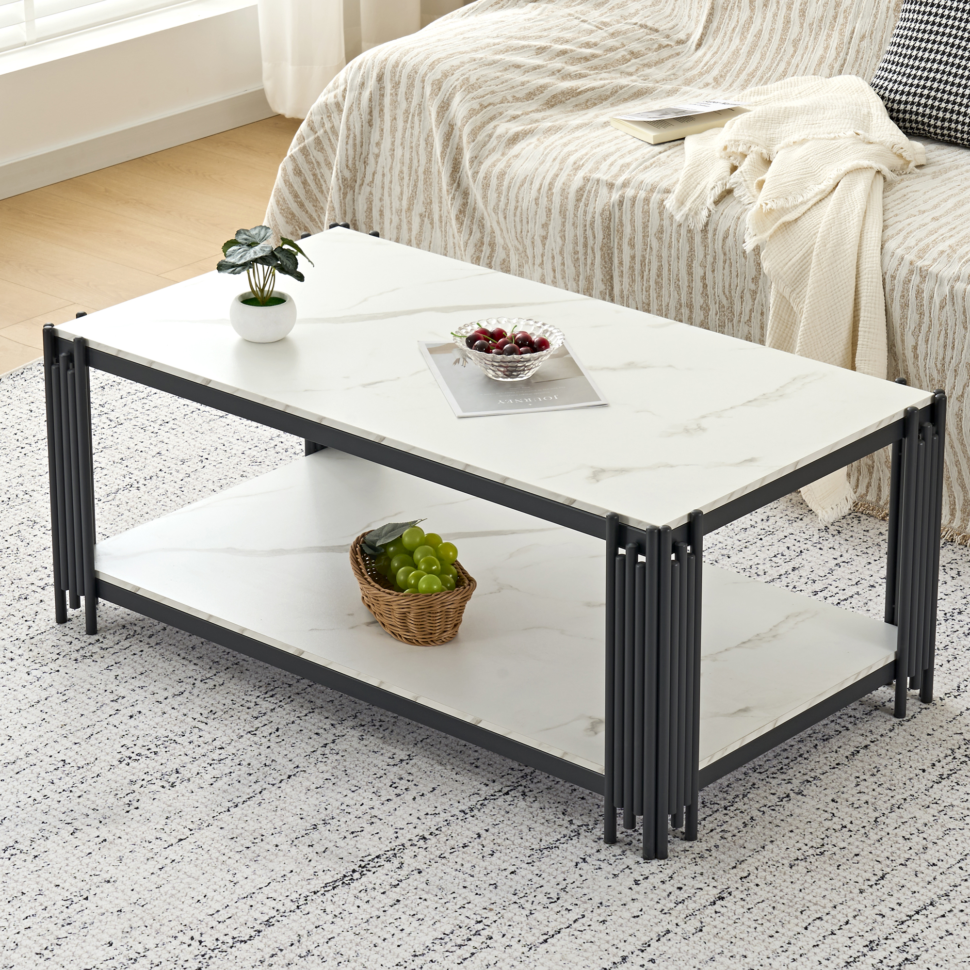 Moderner Couchtisch mit Marmorplatte, schwarzem Metallgestell, Obst und Pflanze.