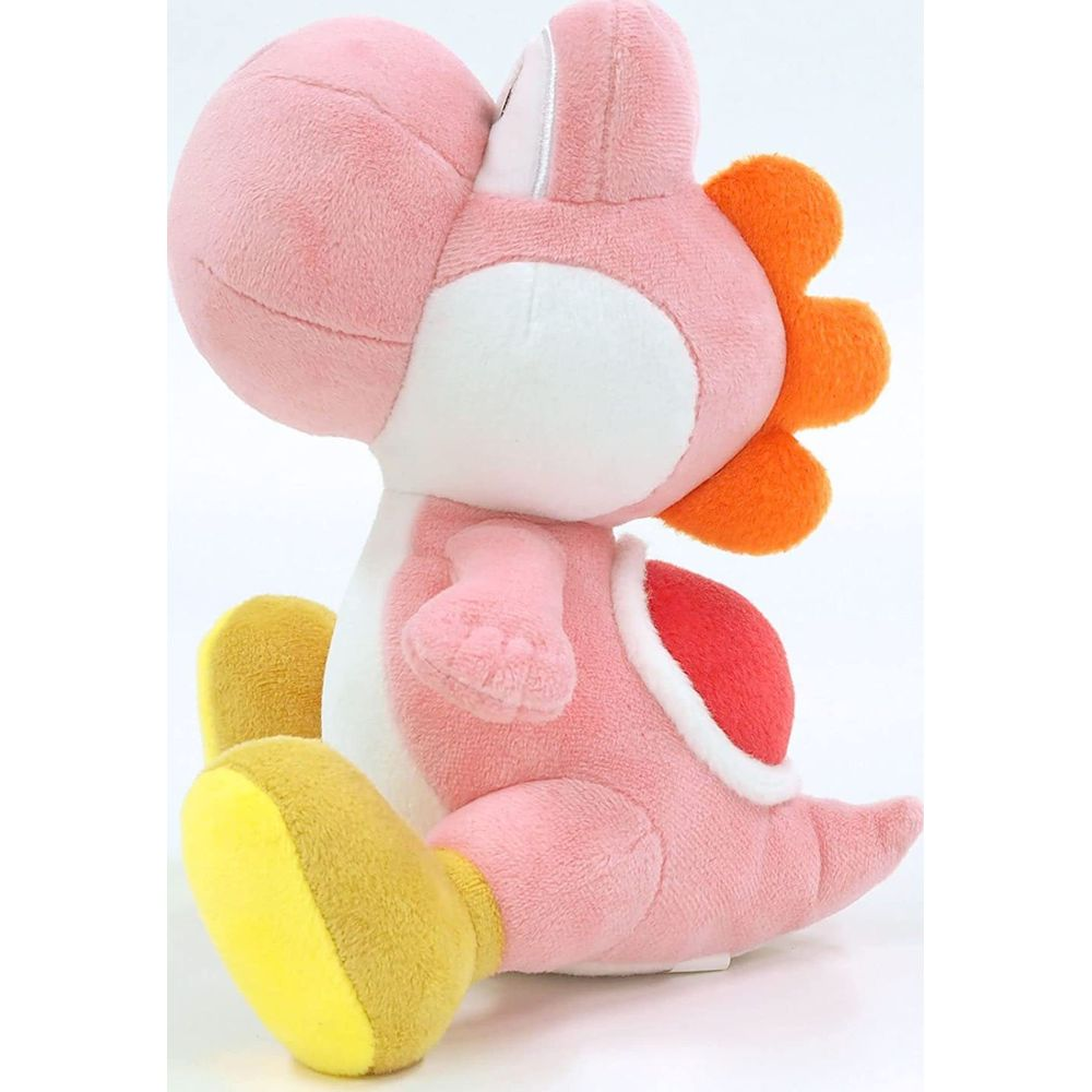 Un peluche rosa di Yoshi con piedi gialli seduto su sfondo bianco.
