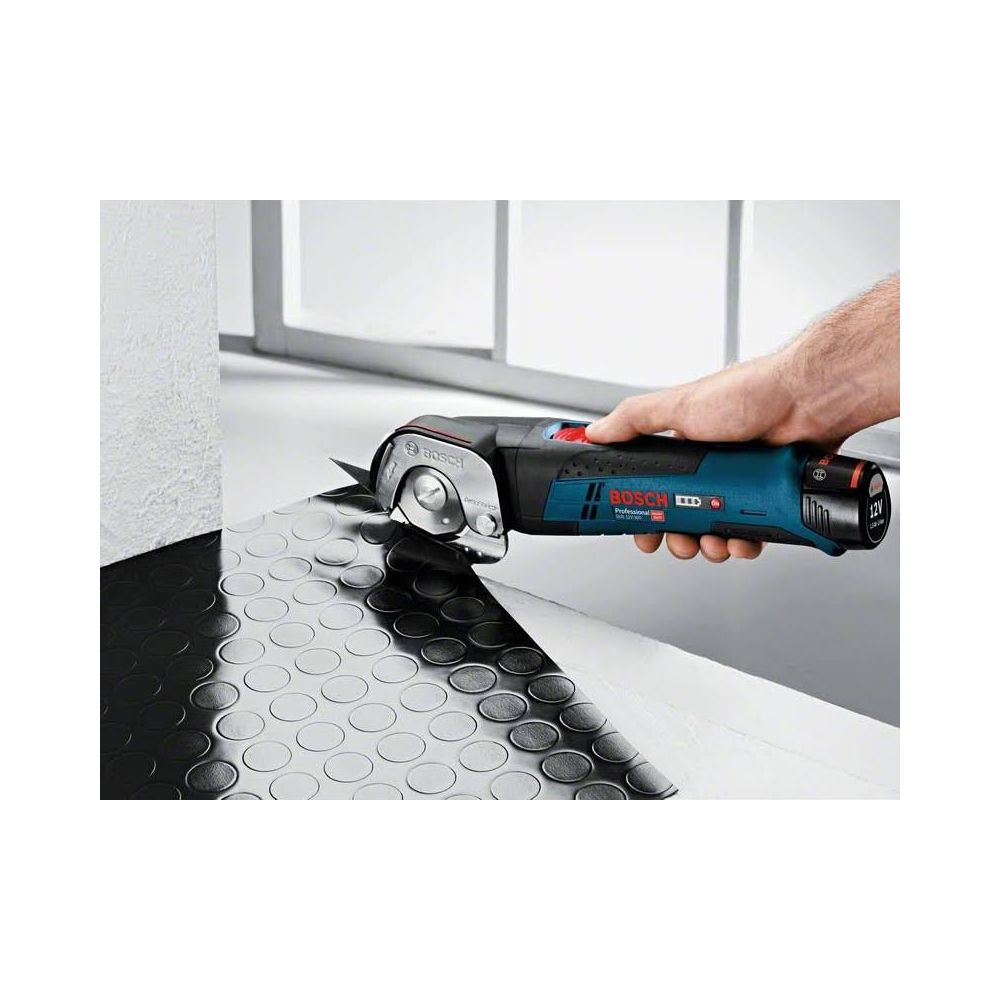 Una mano sostiene unas tijeras inalámbricas Bosch azules cortando material de goma negro.