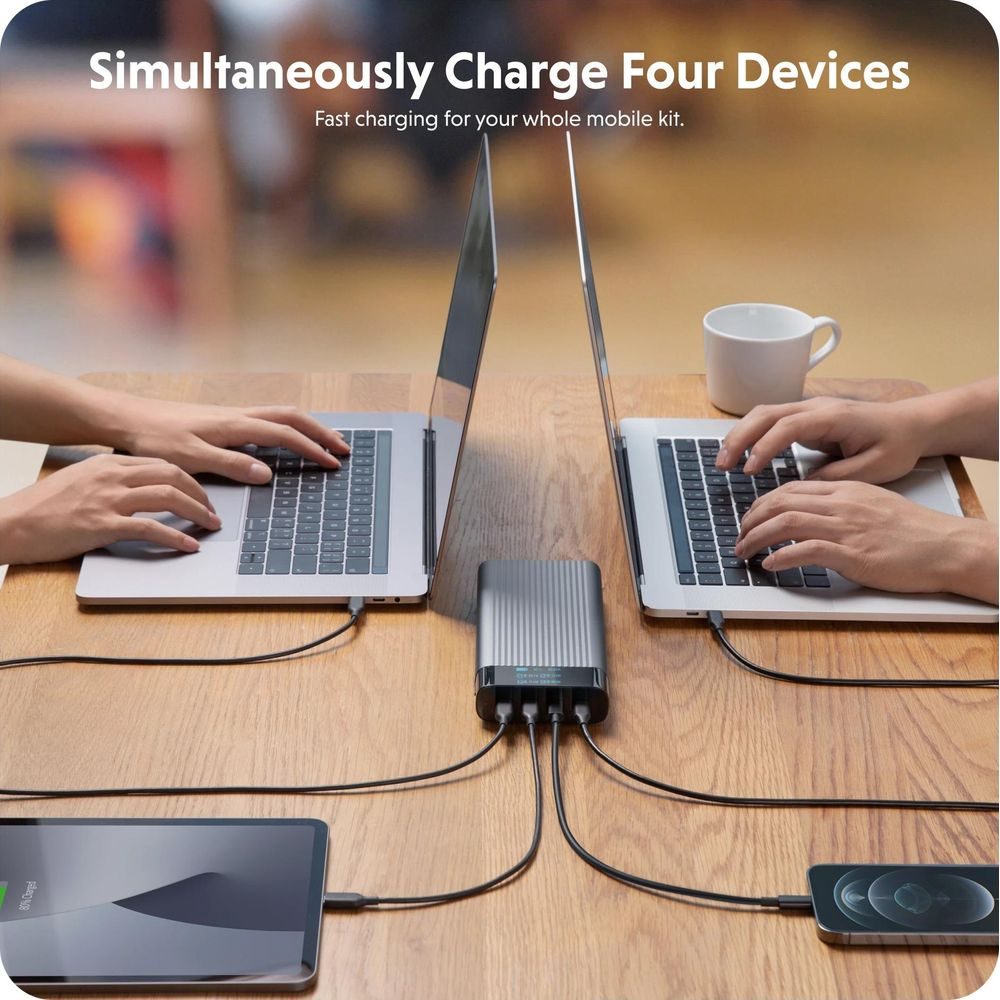 Carica simultanea di quattro dispositivi: laptop, tablet, smartphone su hub.