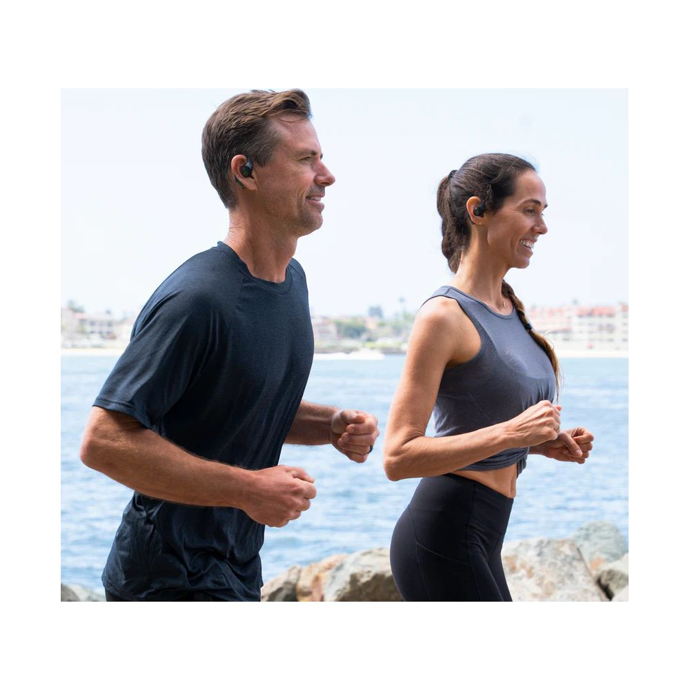 Uomo e donna fanno jogging sul mare, entrambi indossano auricolari.