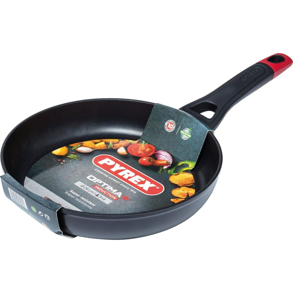Eine schwarze Pyrex Bratpfanne mit rotem Griff und Gemüse auf dem Etikett.
