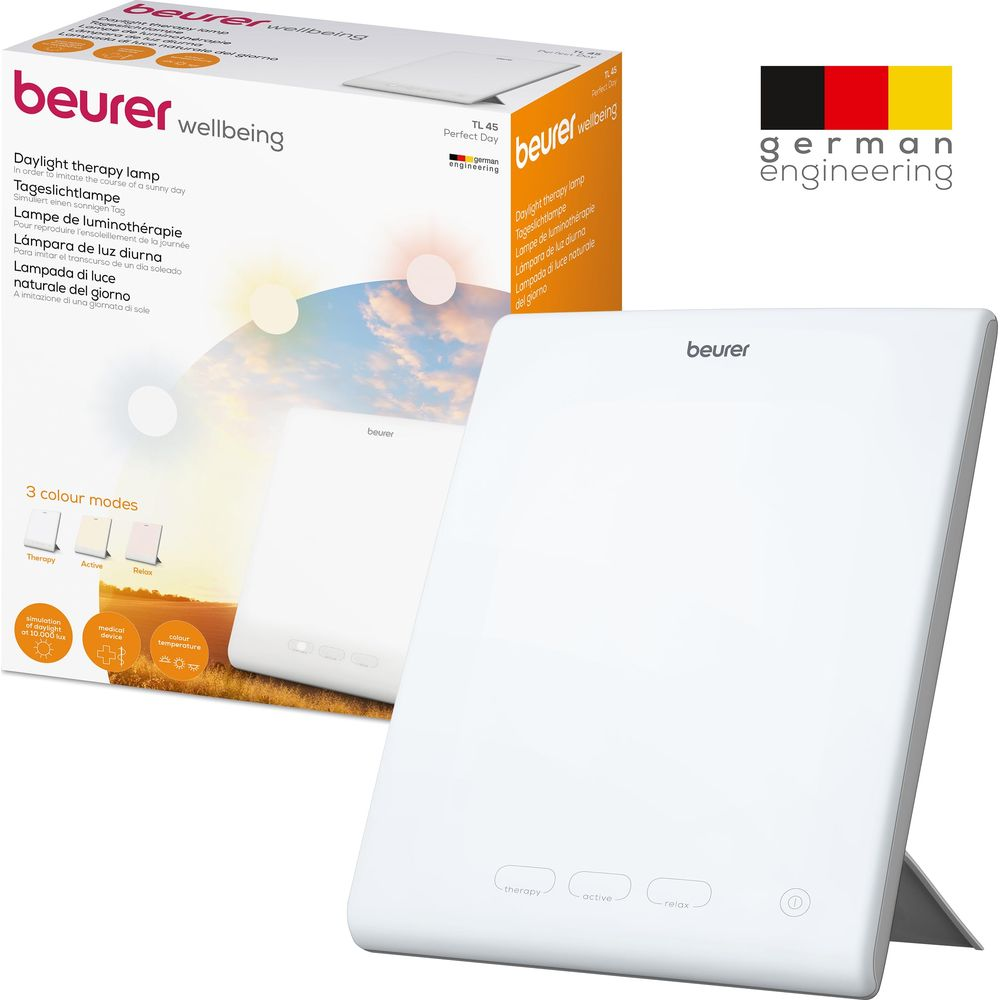Weiße Beurer Tageslichtlampe mit drei Modi und Sonnenuntergangslandschaft auf der Verpackung.