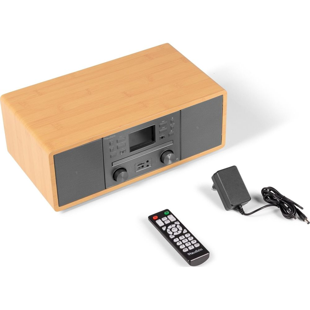 Una radio de madera con mando a distancia y adaptador de corriente.
