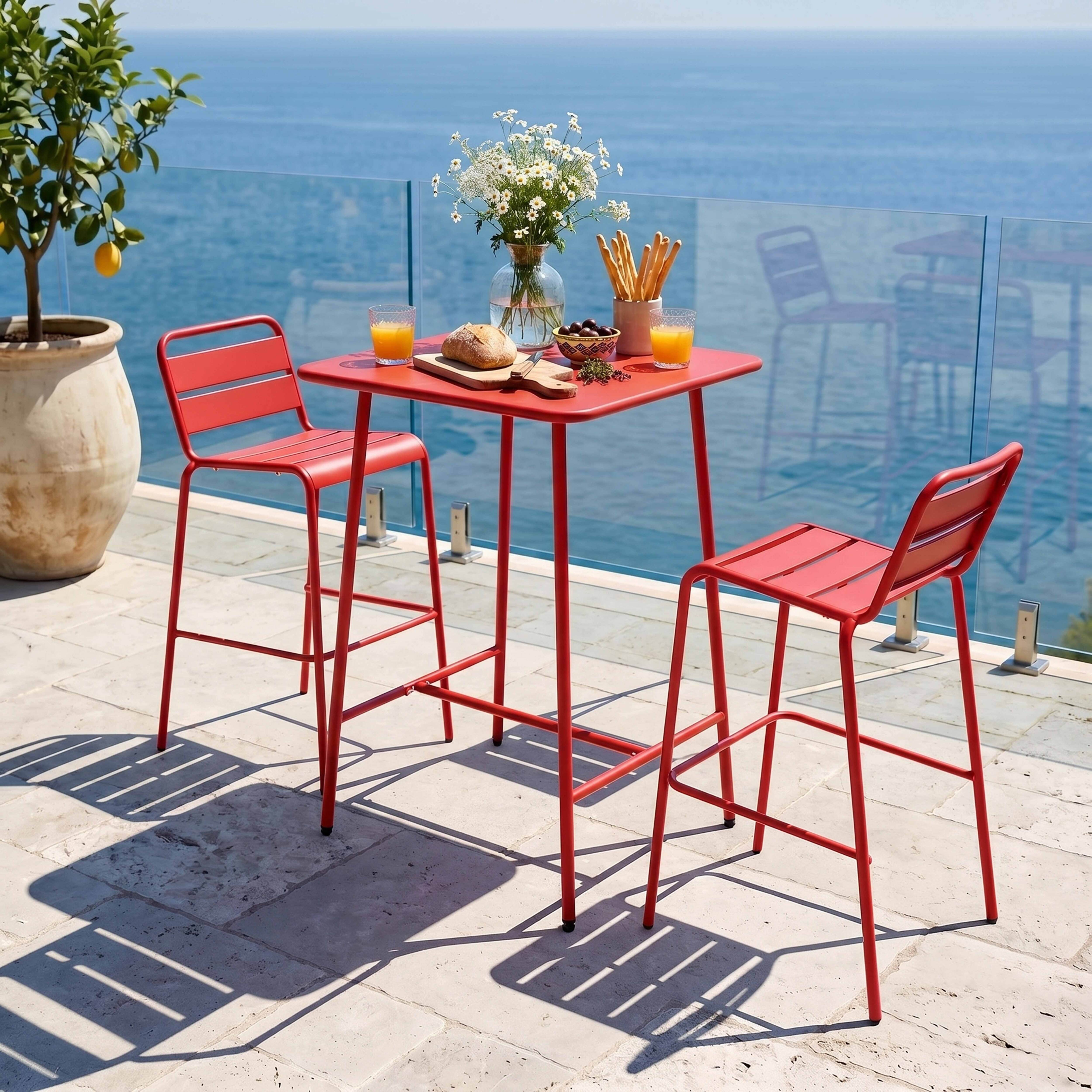 Roter Tisch und Stühle am Meer mit Zitronenbaum und Blumen.
