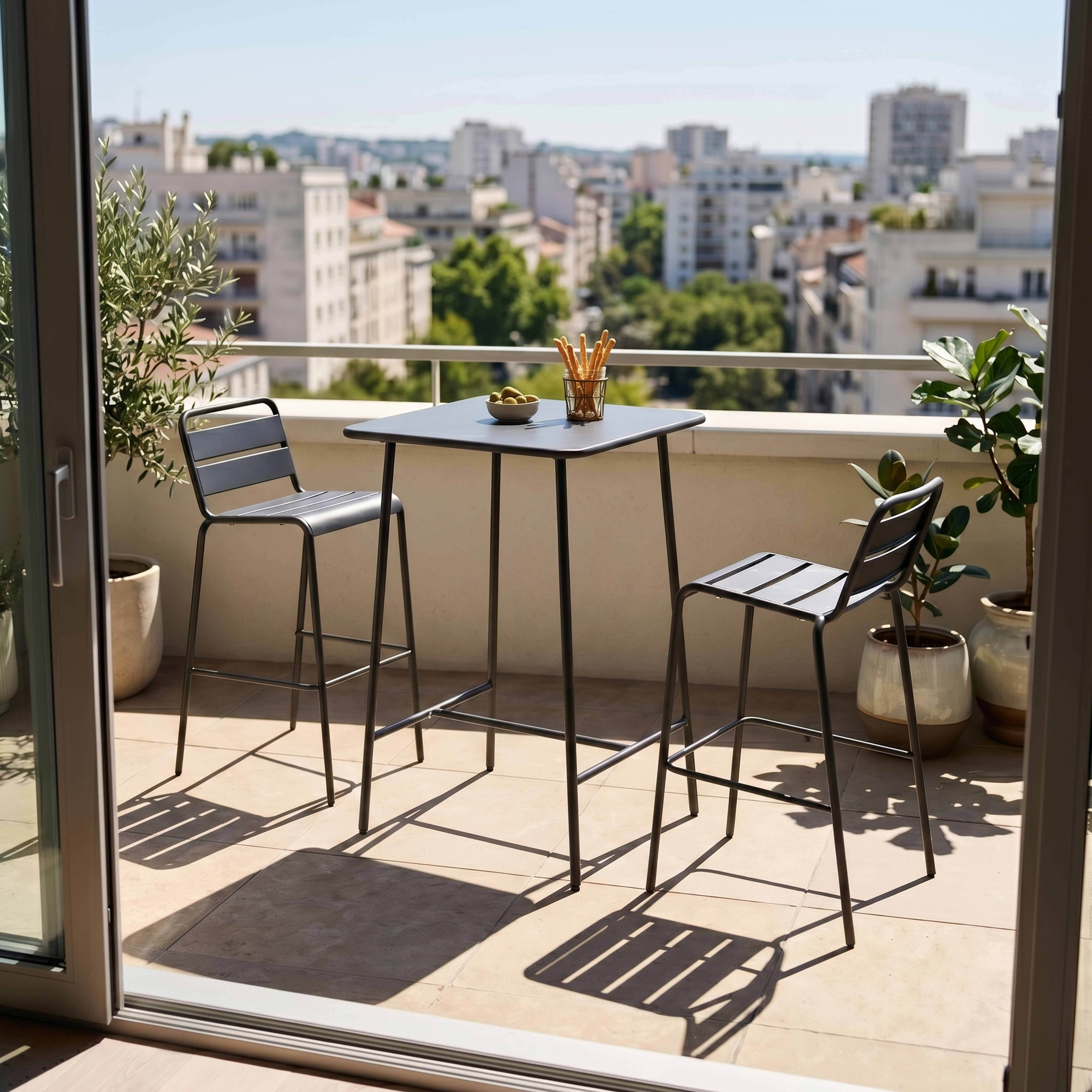 Ein Bistrotisch mit zwei Hockern auf einem Balkon mit Stadtblick.