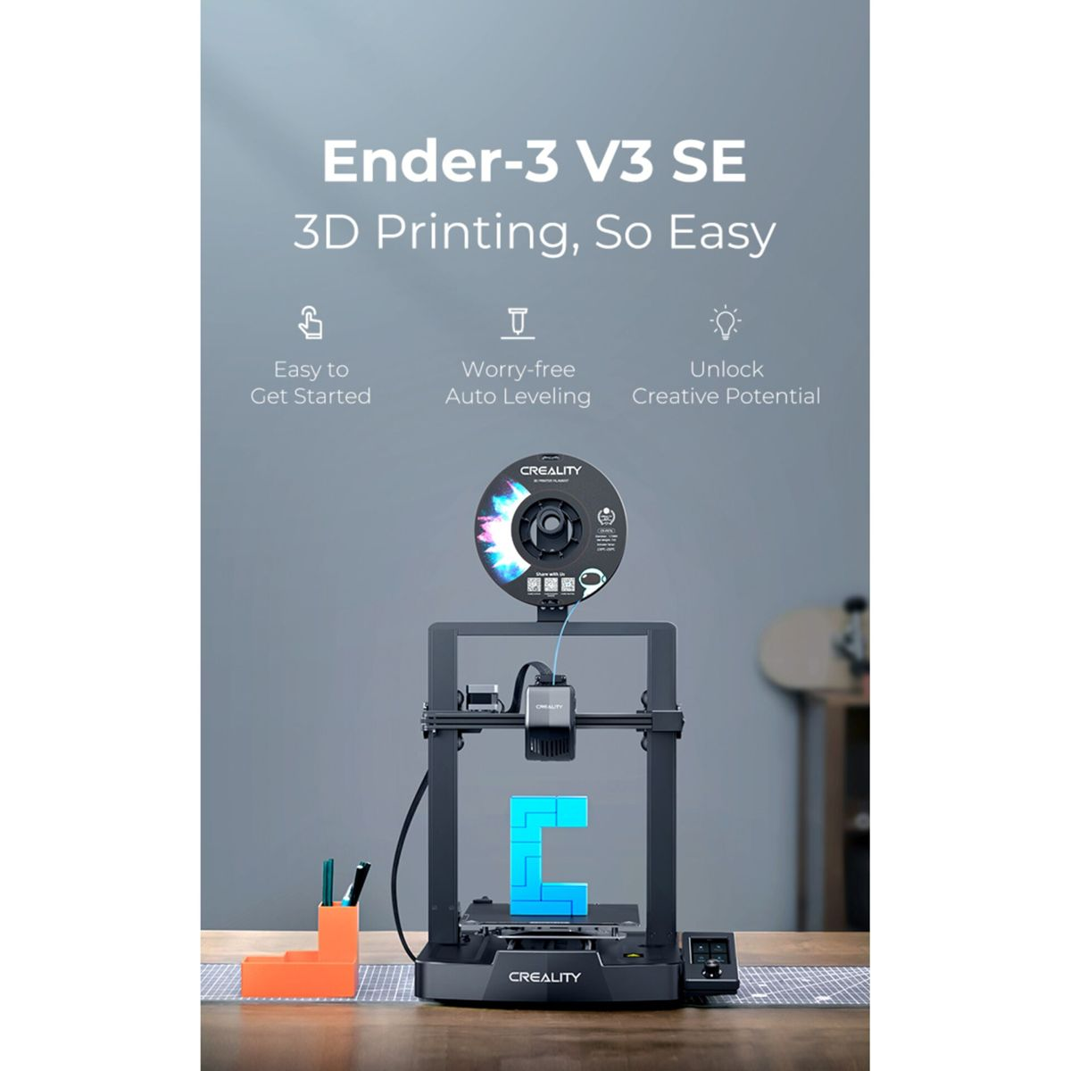 Drukarka 3D Ender-3 V3 SE drukuje niebieski obiekt na drewnianej powierzchni.