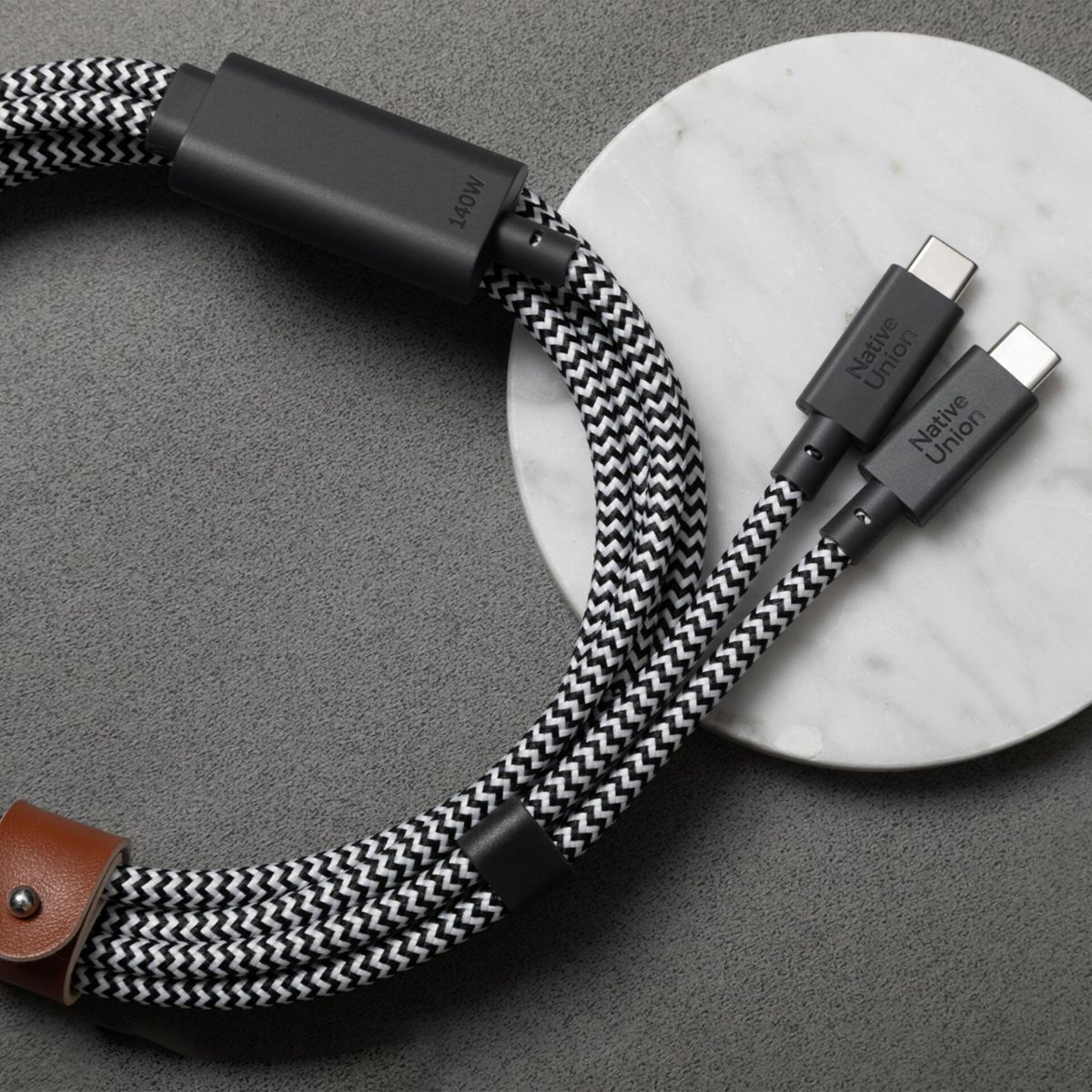 Kabel mit schwarz-weißem Fischgrätmuster und USB-C-Anschlüssen, 140W.