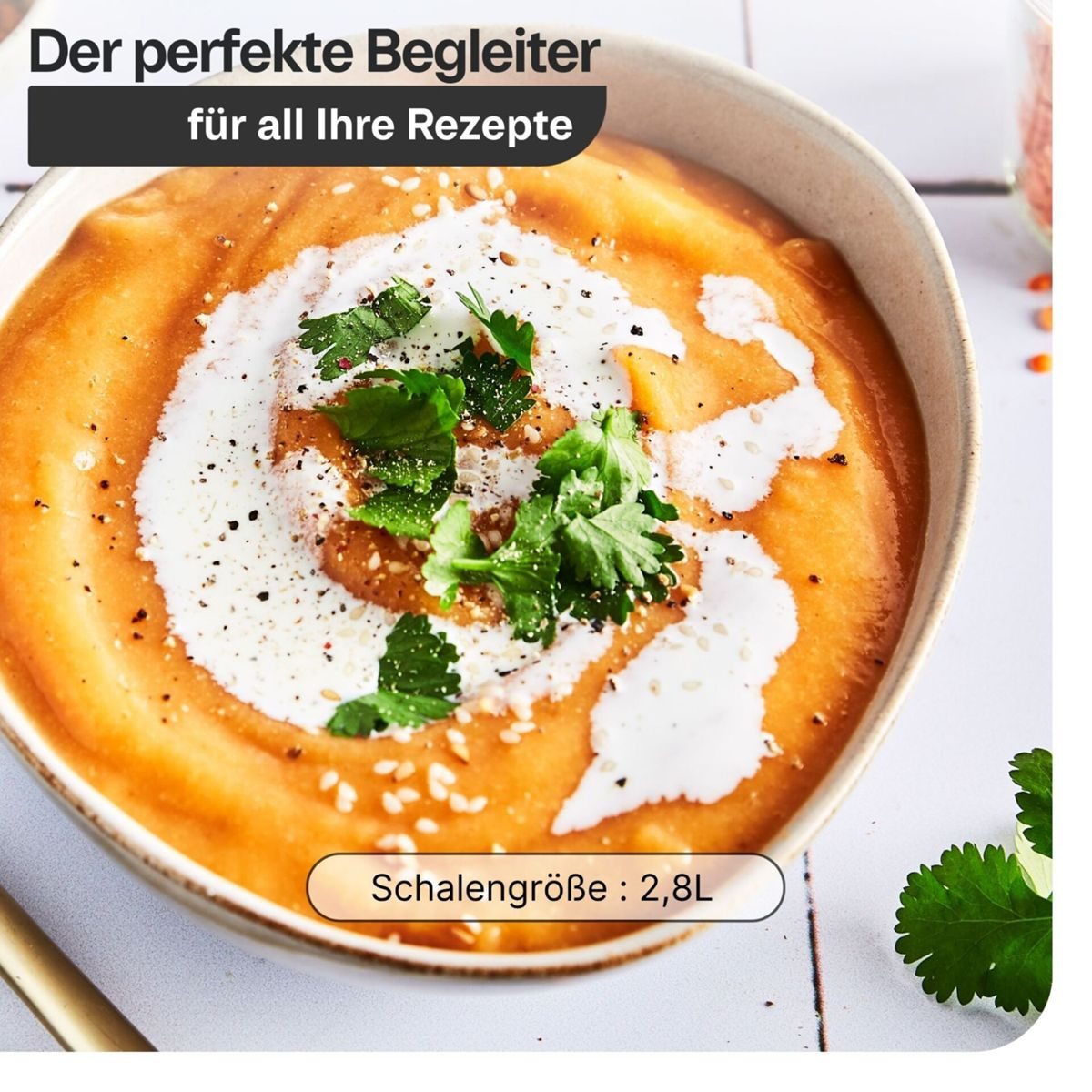 Eine Schale cremiger orangefarbener Suppe, garniert mit Sahne, Koriander und Sesam.