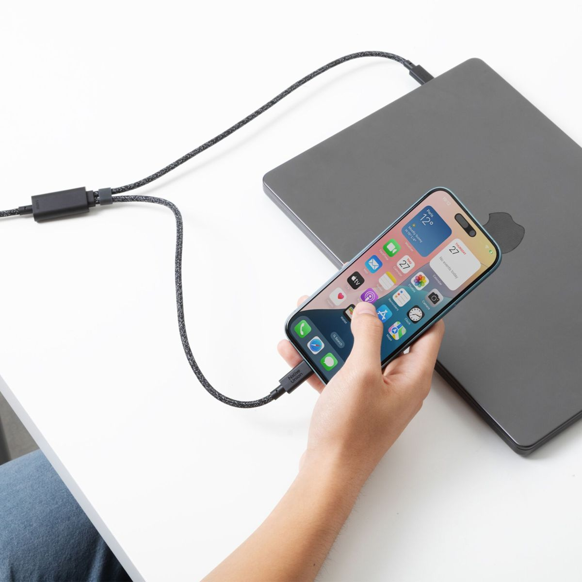 Ein Handy wird mit einem Laptop verbunden, um es zu laden.