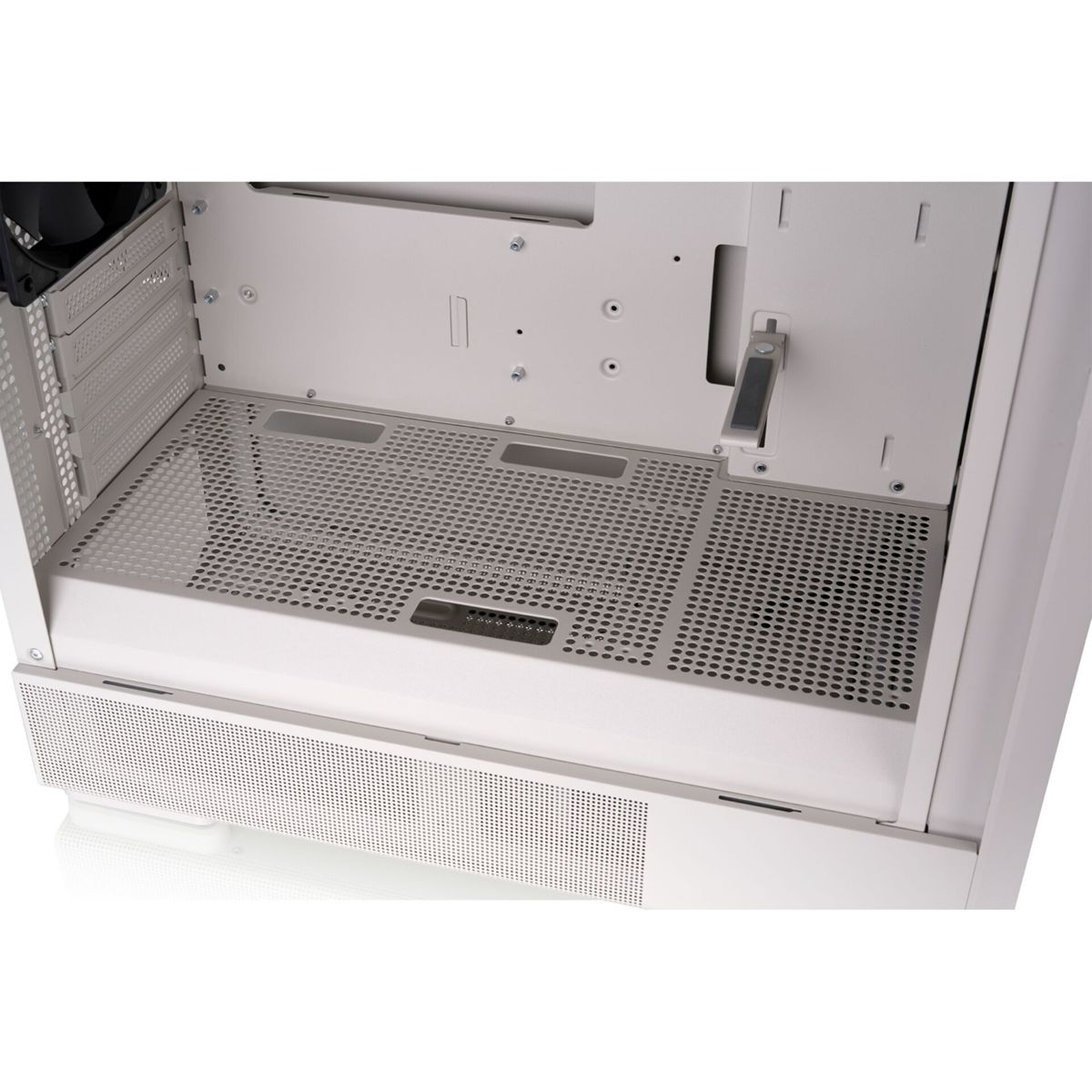 Interior de una caja de ordenador blanca con ventilador y superficies perforadas.