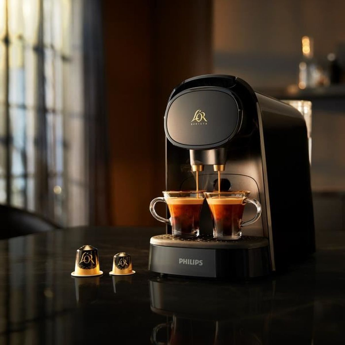 Una macchina da caffè nera prepara due tazzine di espresso, con cialde nelle vicinanze.