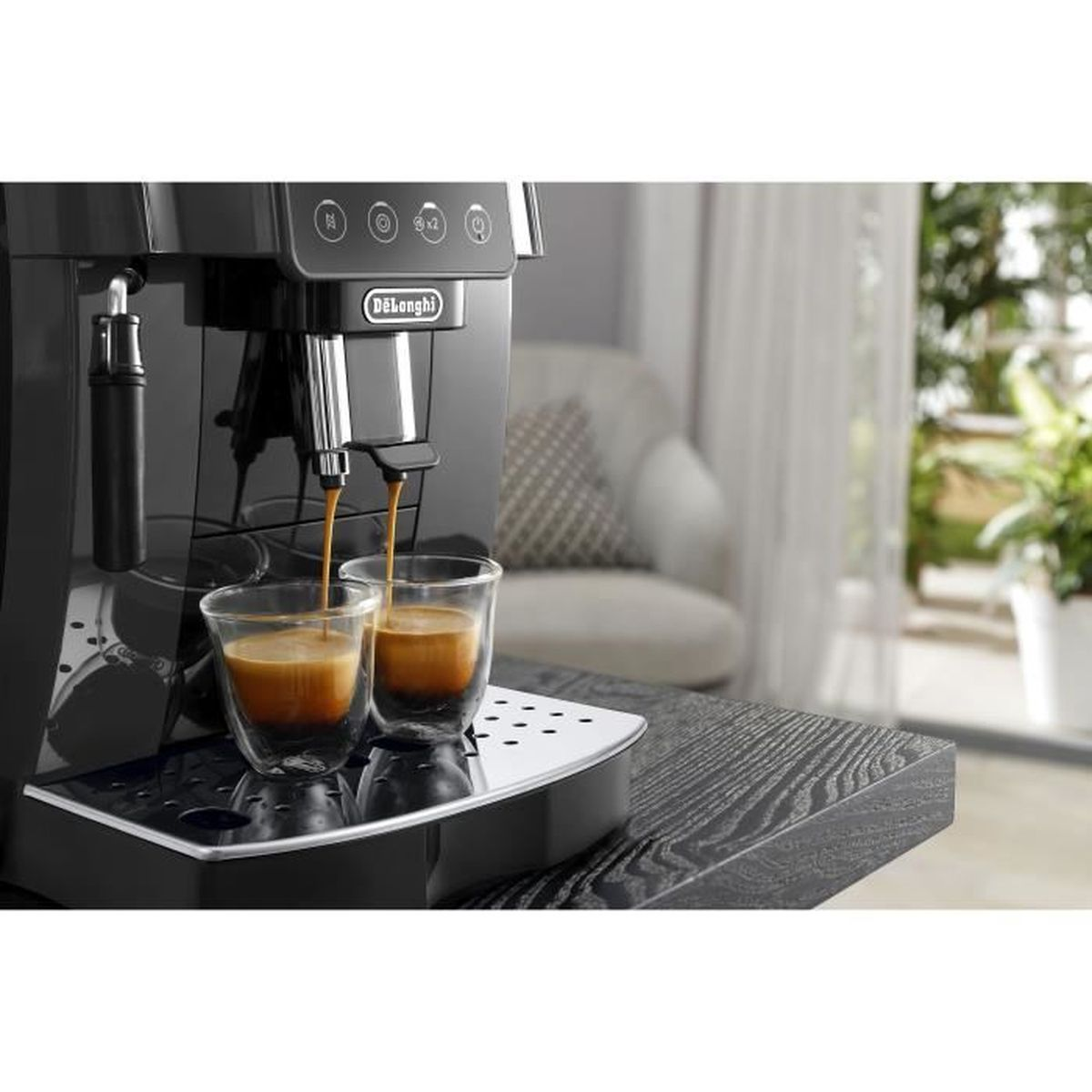 Una macchina da caffè nera prepara due espresso in bicchieri di vetro su un tavolo di legno.