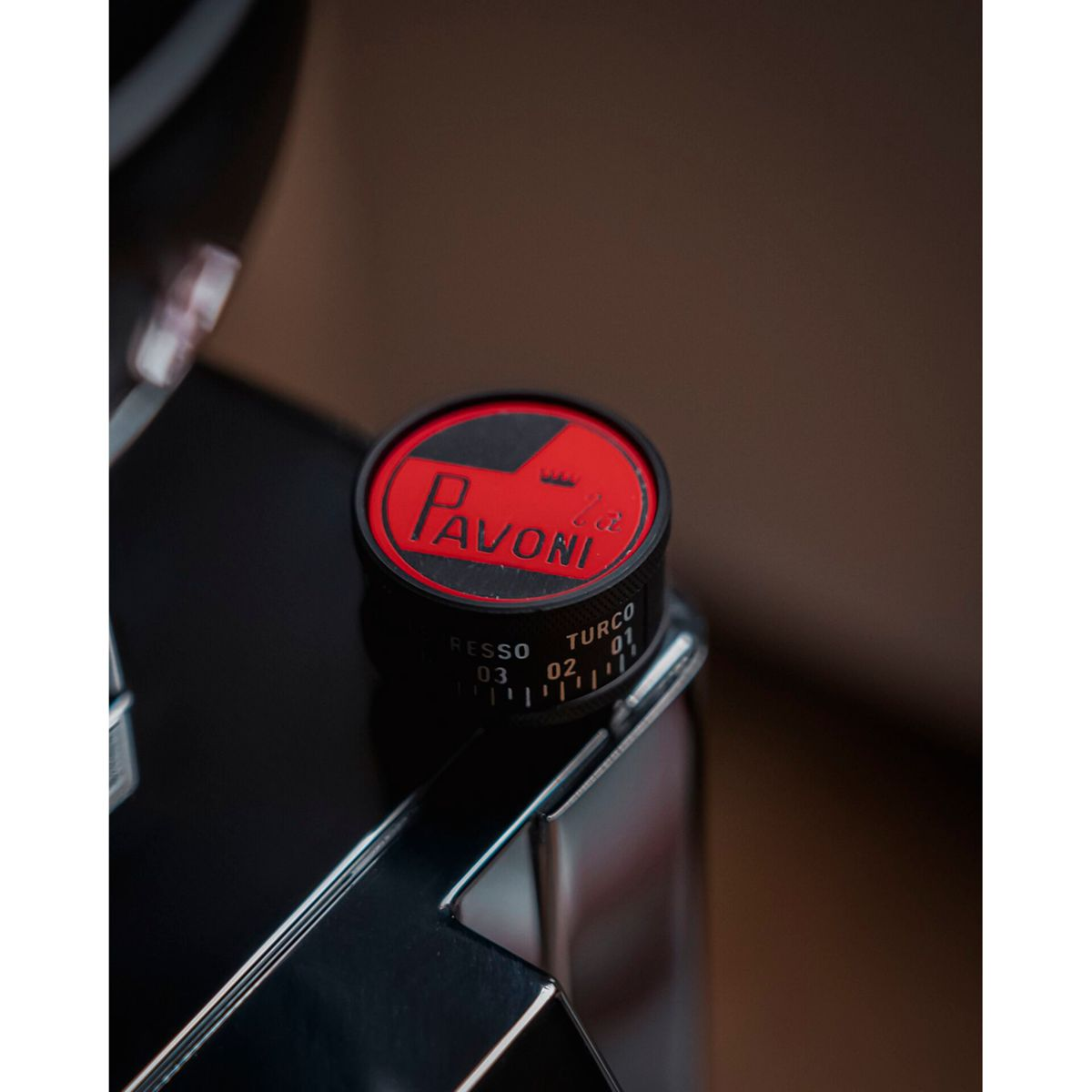 Una manopola nera per macchina da caffè La Pavoni con logo rosso e impostazioni numerate.