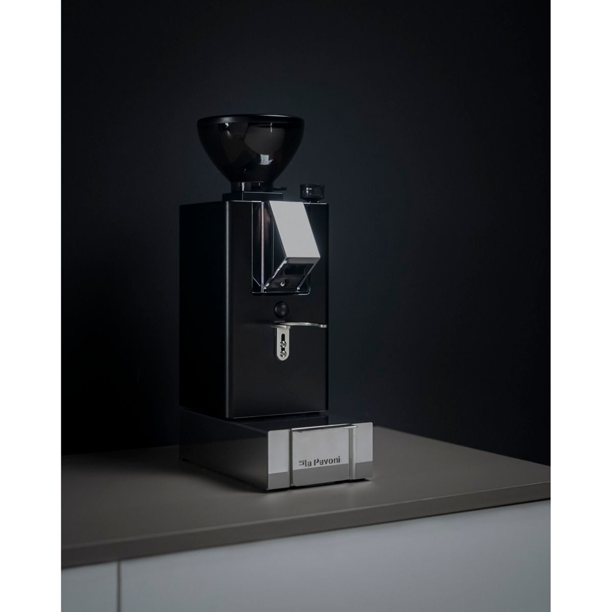 Tramoggia nera per macinacaffè su macinacaffè nero lucido con base in metallo.