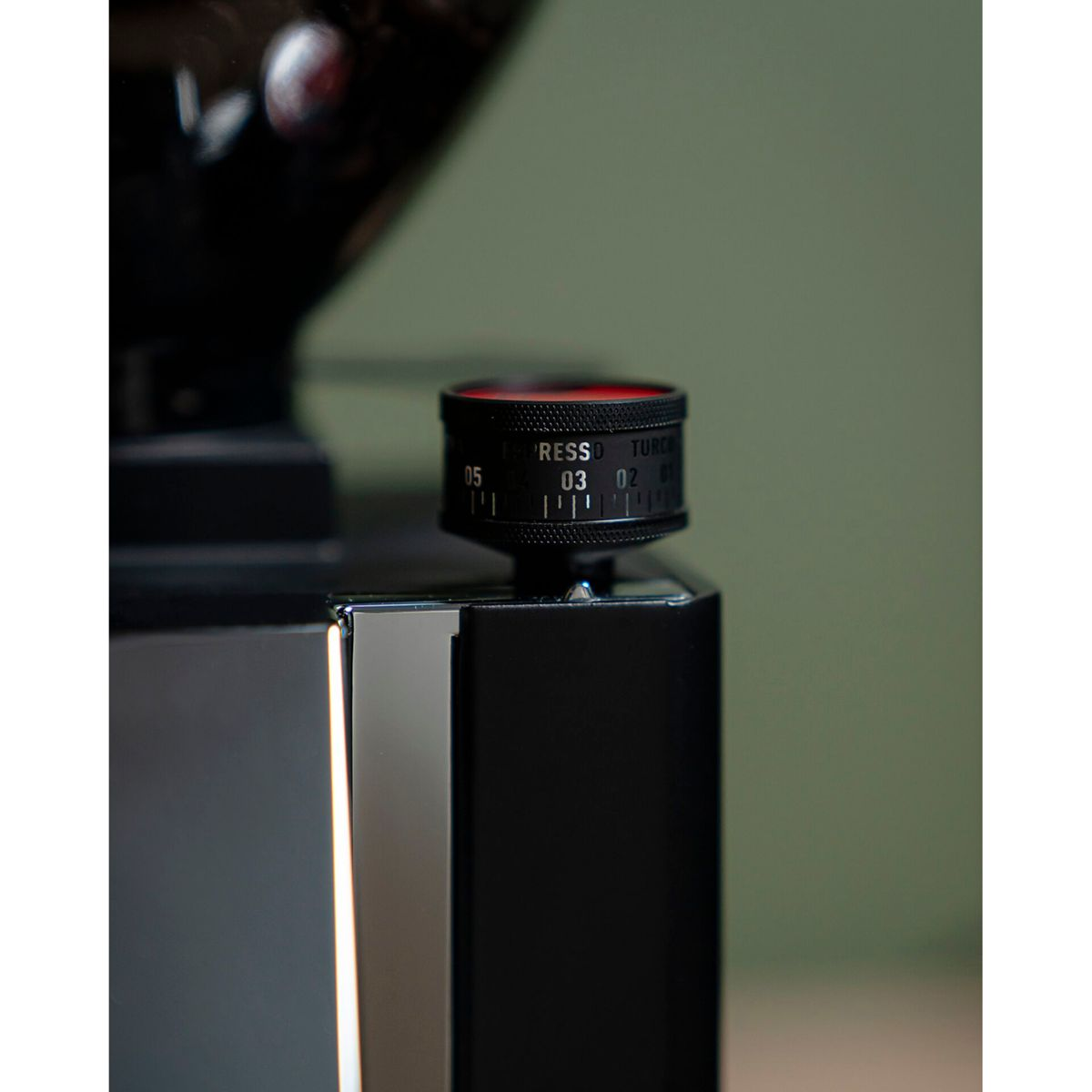 Primo piano di un macinacaffè nero con anello di regolazione rosso e numeri.