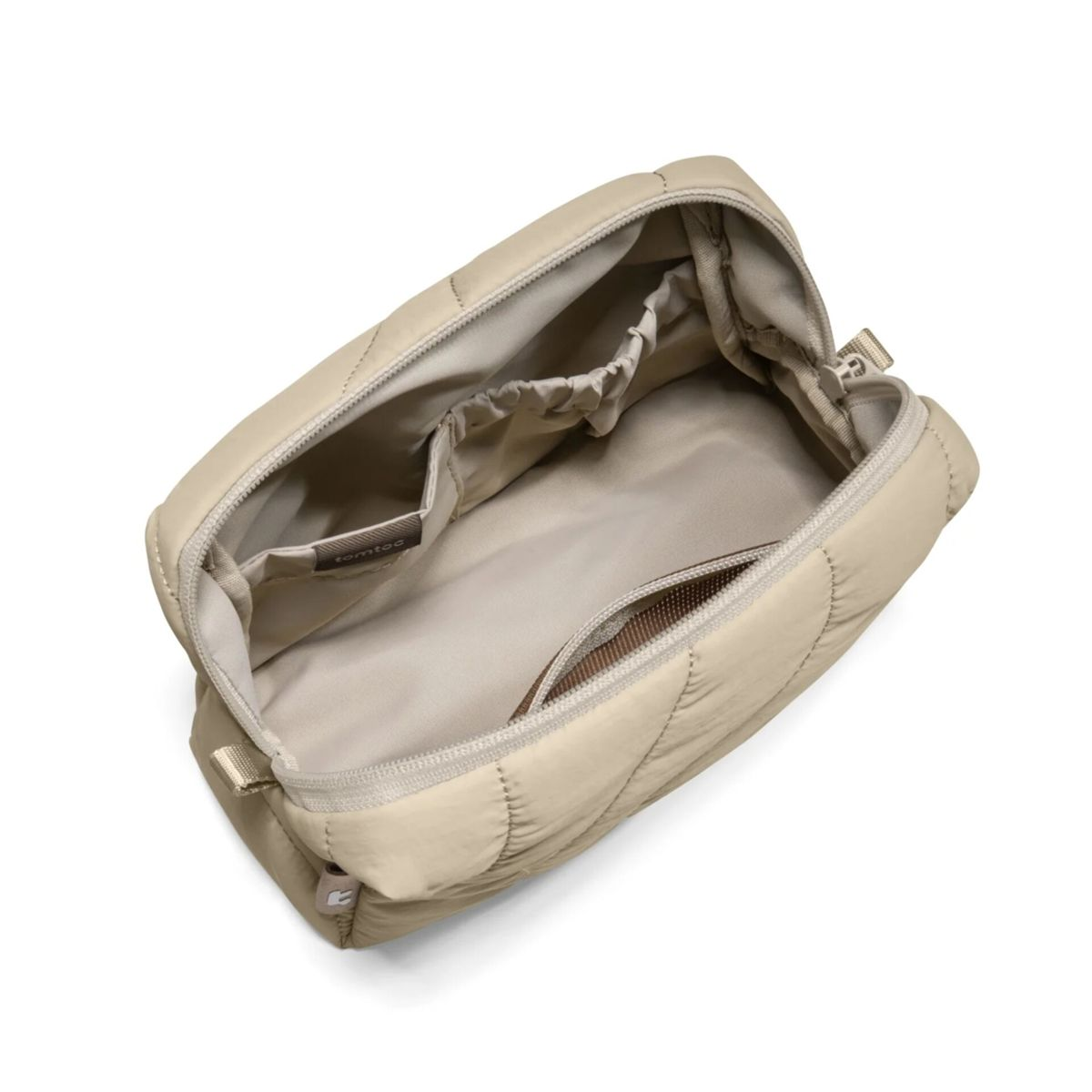 Eine gesteppte, cremefarbene Kulturtasche mit offenem Fach und Reißverschluss.