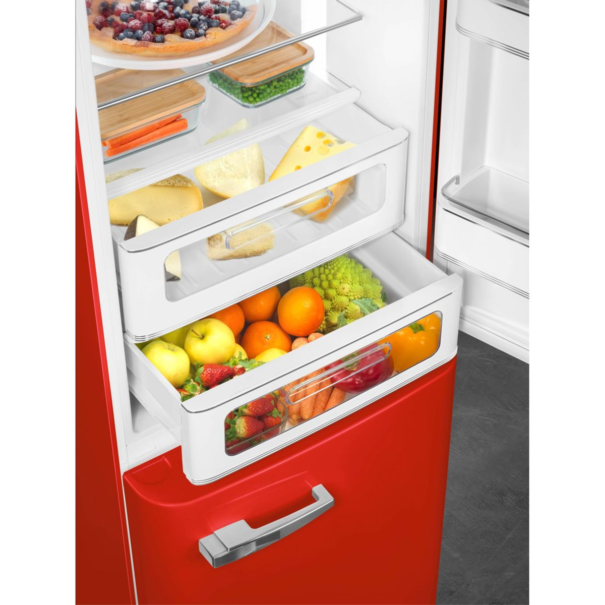 Un refrigerador rojo abierto muestra estantes con frutas, verduras y queso.