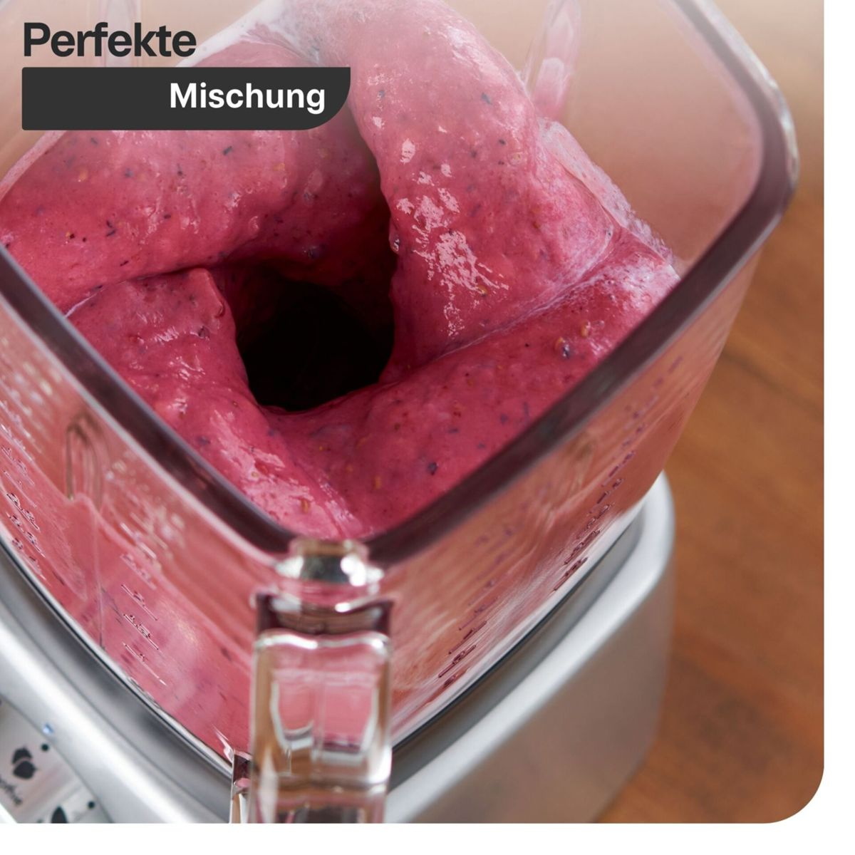 Un frullato rosa viene frullato in un frullatore trasparente, creando un vortice.