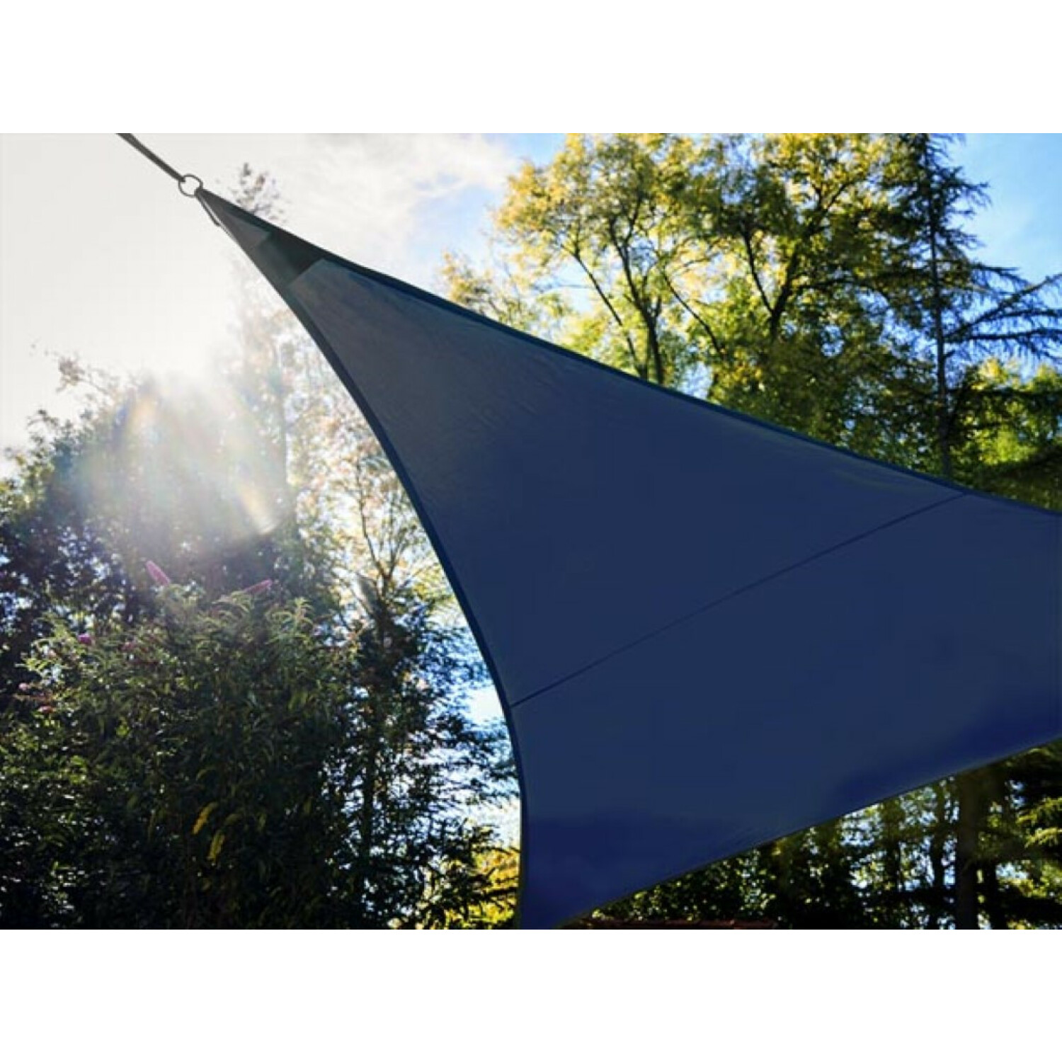 Una vela parasole blu scuro si estende davanti ad alberi e cielo blu.