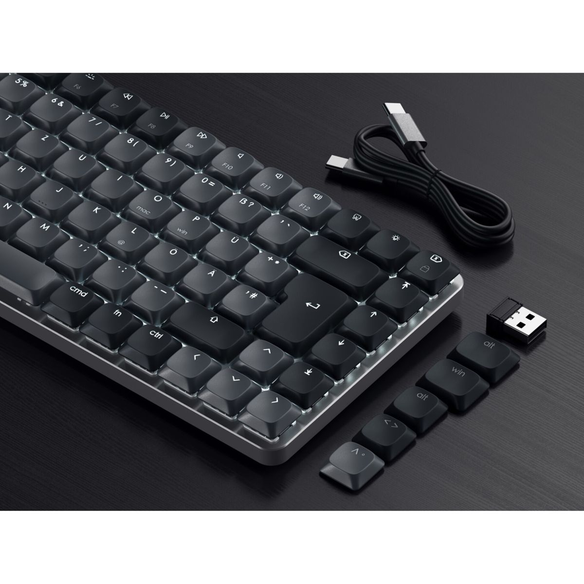 Eine schwarze Kompakt-Tastatur mit weißer Hintergrundbeleuchtung, USB-C-Kabel und USB-Dongle.