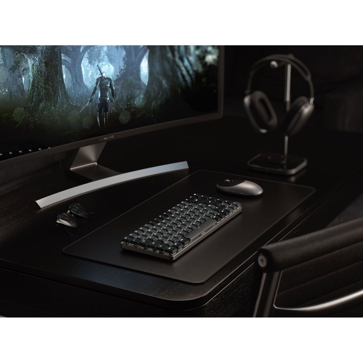 Ein dunkler Schreibtisch mit Tastatur, Maus, Brille, Kopfhörern und einem Monitor, der ein Spiel zeigt.