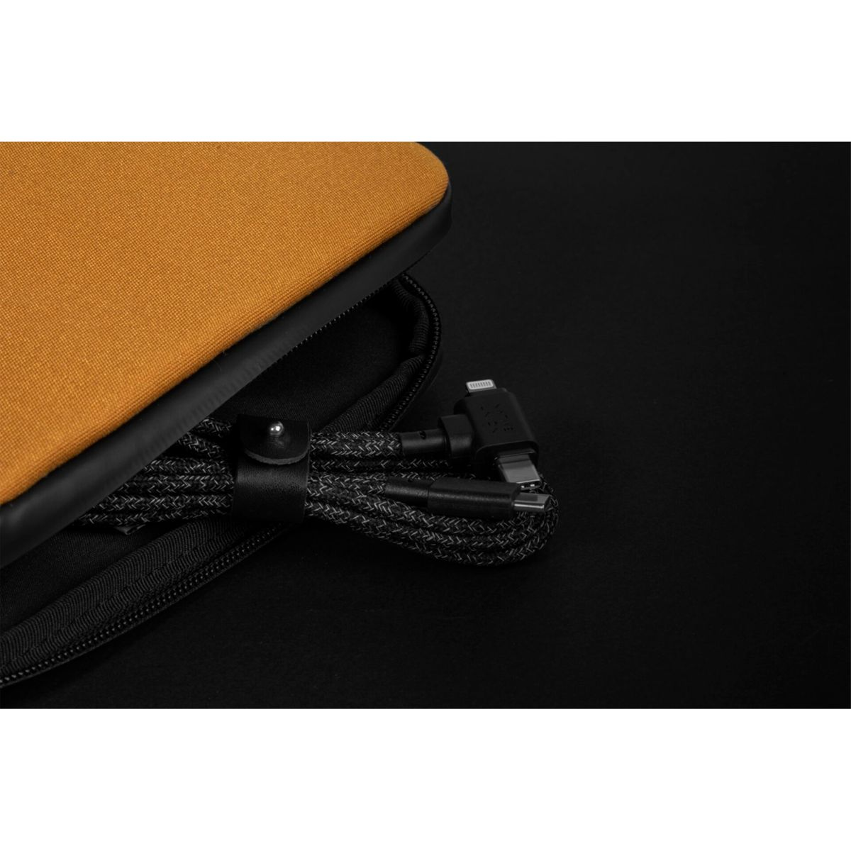 Custodia arancione con cerniera nera contiene un cavo intrecciato nero con connettori USB-C e Lightning.