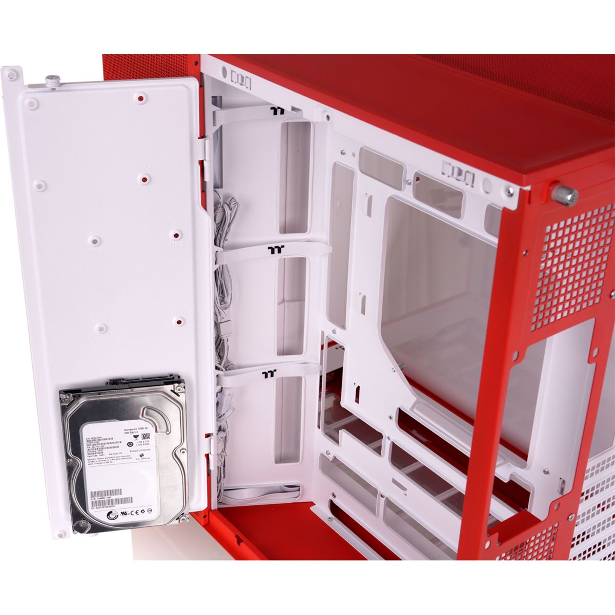 Interior de caja de PC roja y blanca con disco duro en la puerta abierta.