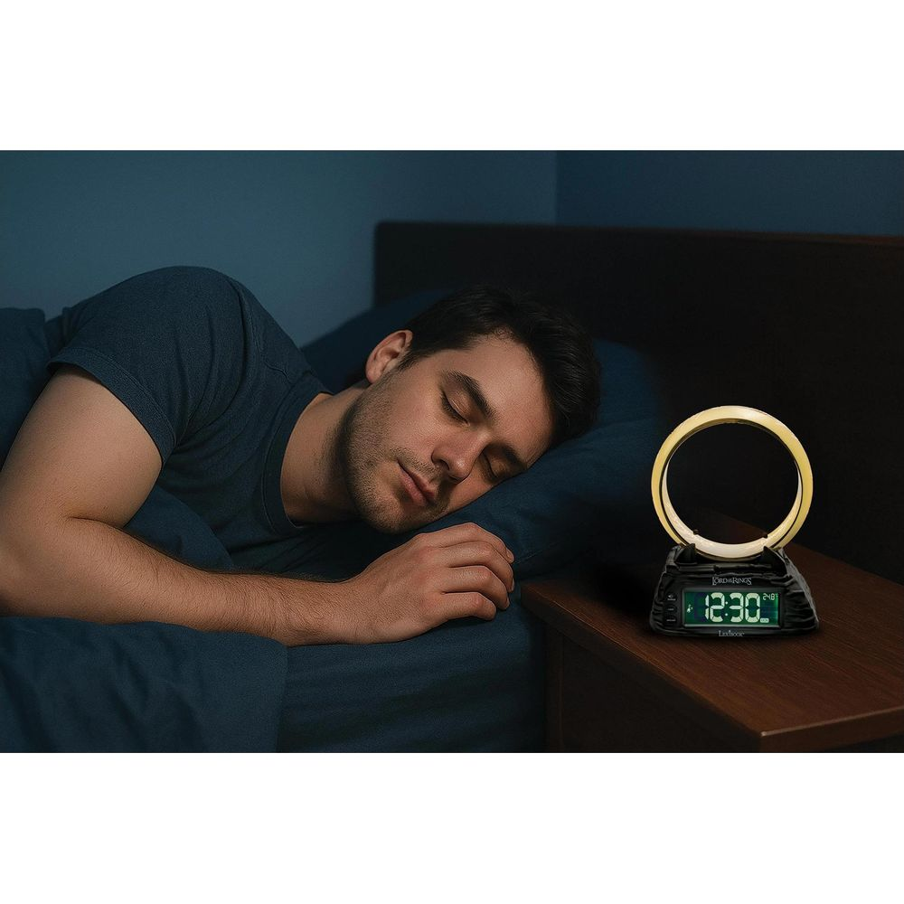 Mann schläft im Bett neben einem Wecker auf dem Nachttisch.