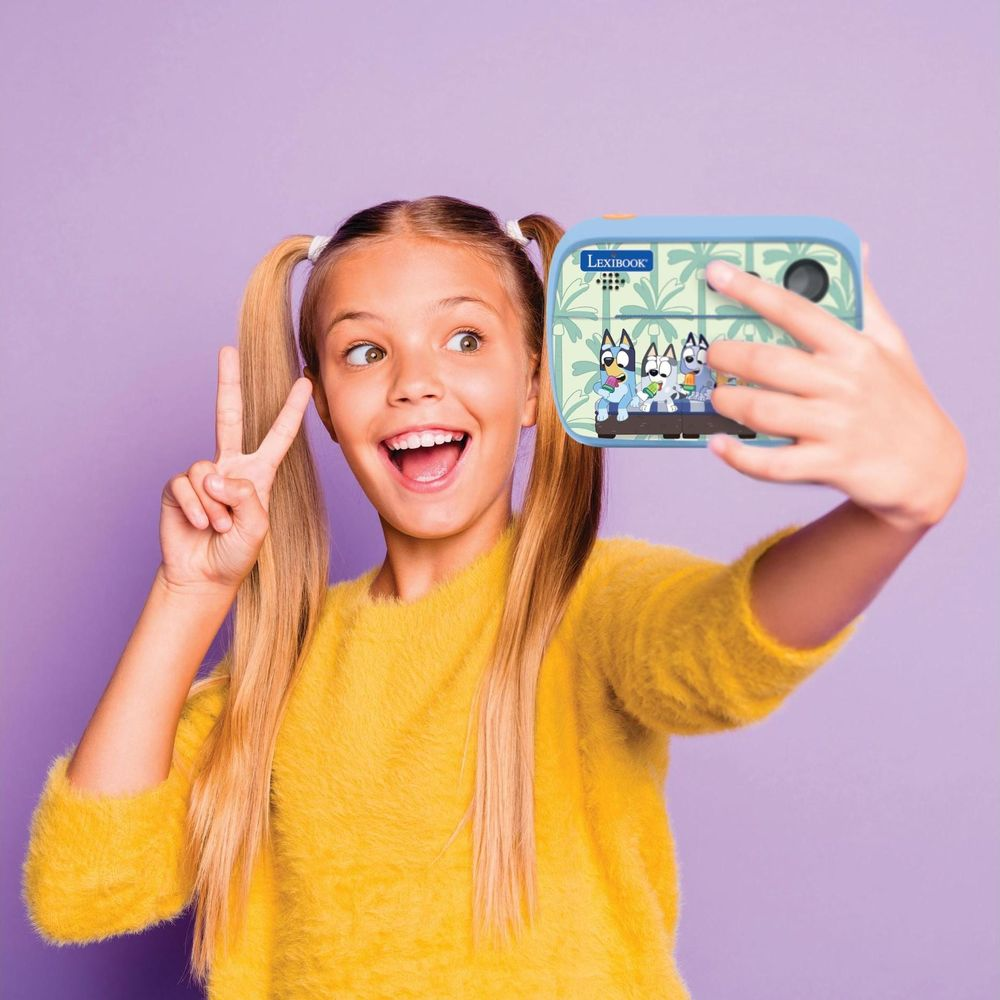 Ein Mädchen mit Pferdeschwänzen macht ein Selfie mit einer blauen Kamera, die Bluey zeigt.