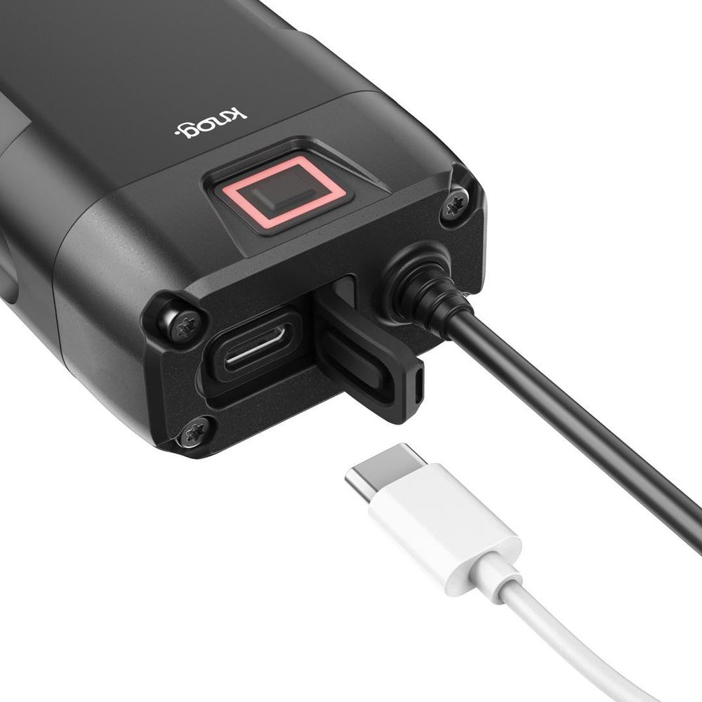 Schwarzes Gerät mit USB-C-Anschluss, rotem quadratischem Knopf und Kabeln. Ein weißes USB-C-Kabel wird angeschlossen.