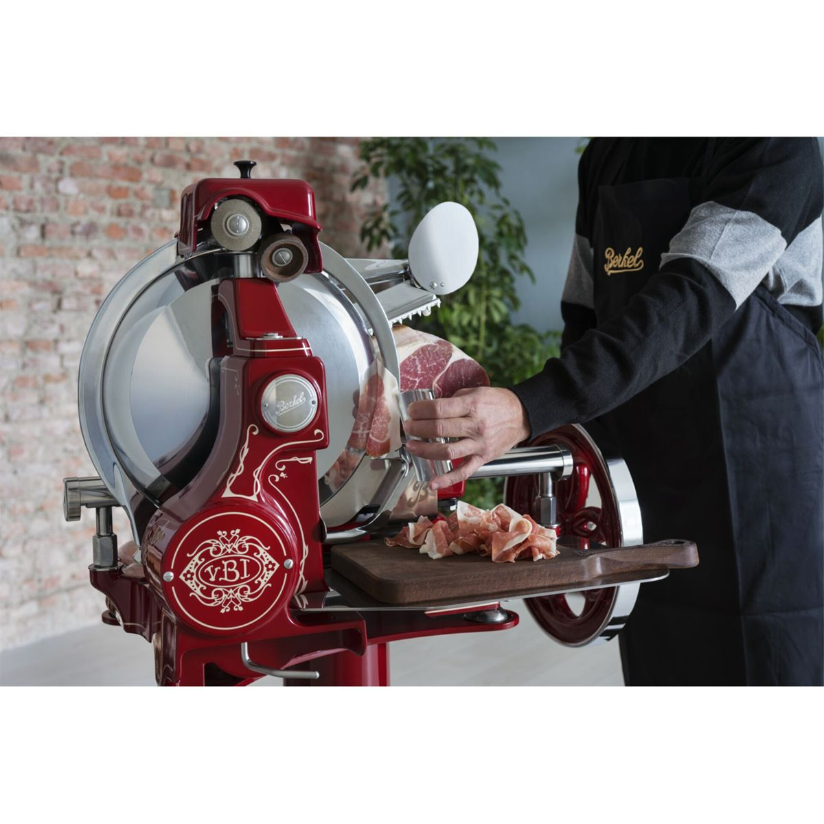 Eine rote Fleischschneidemaschine mit einem Mann, der Fleisch schneidet.