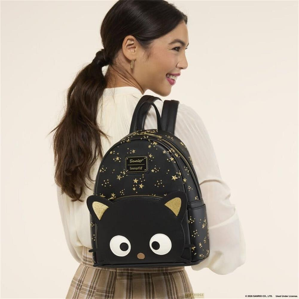 Frau mit schwarzem Rucksack mit Sternen und Katzenmotiv. Goldene Sterne auf schwarzem Hintergrund.