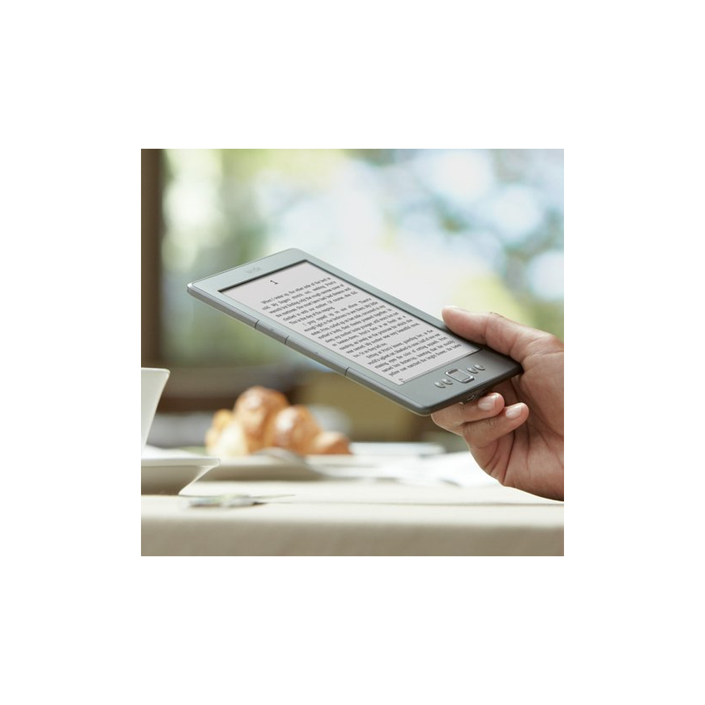 Eine Hand hält einen E-Reader mit Text vor einem unscharfen Hintergrund mit Gebäck.