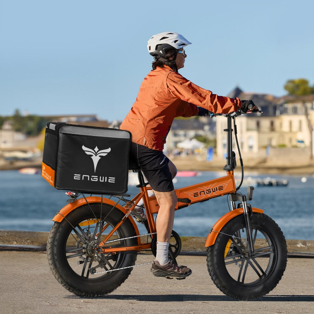 Eine Person fährt ein oranges Klapprad mit einer schwarzen Liefertasche auf dem Rücken.