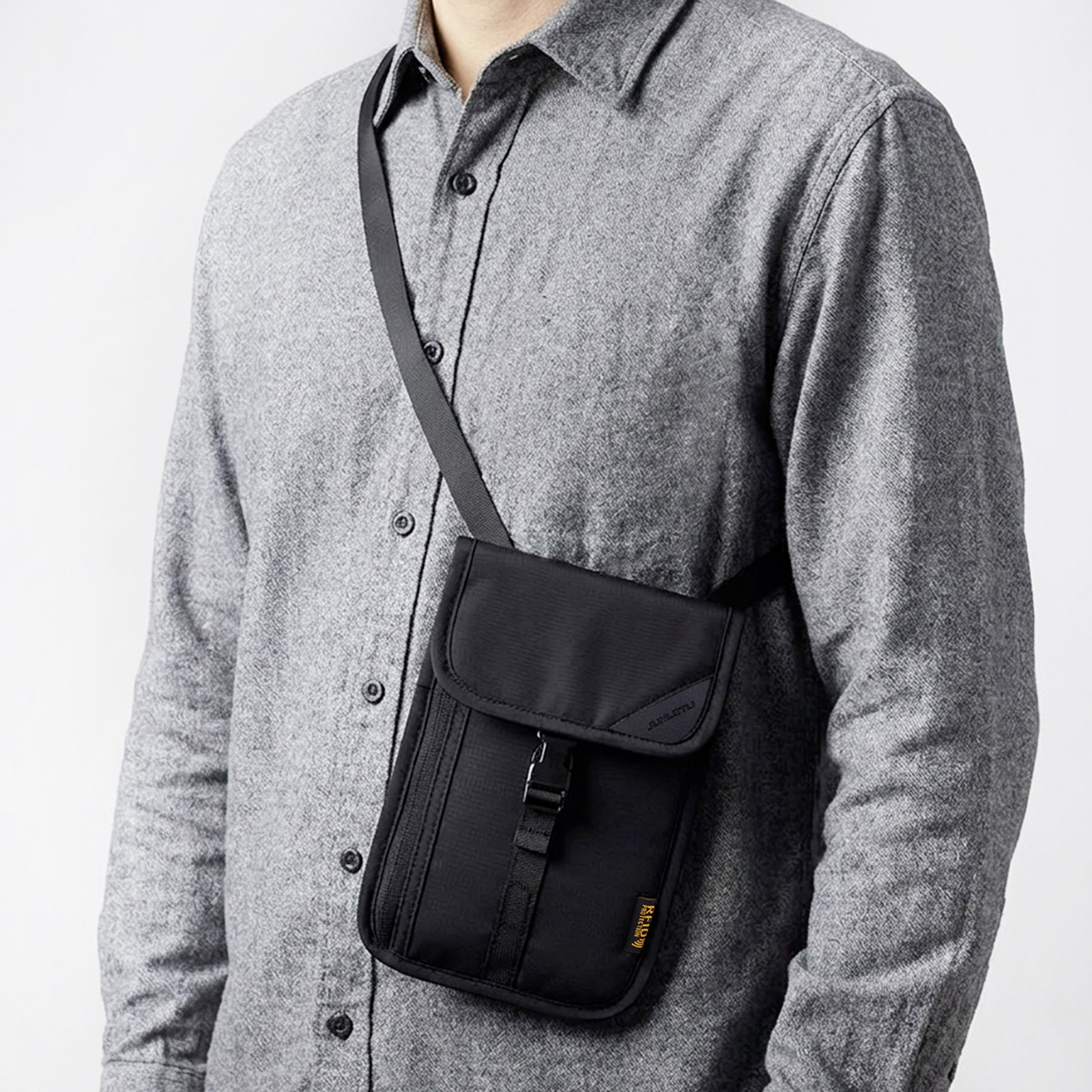 Hombre con bolso cruzado negro sobre camisa gris.