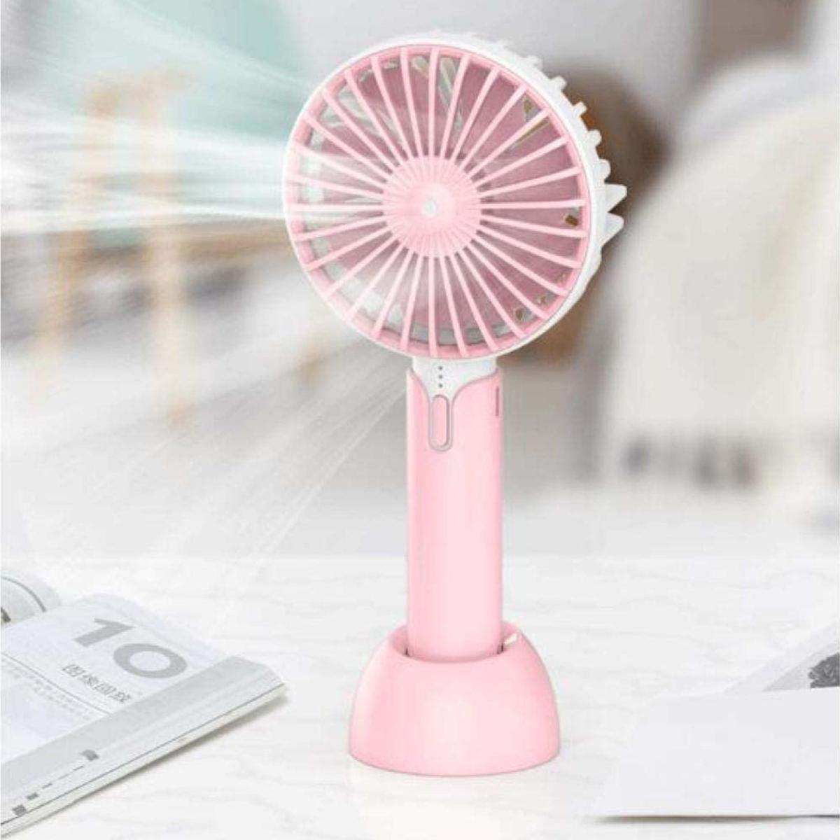 Un piccolo ventilatore rosa con bordi bianchi e pale multiple poggia su un supporto.