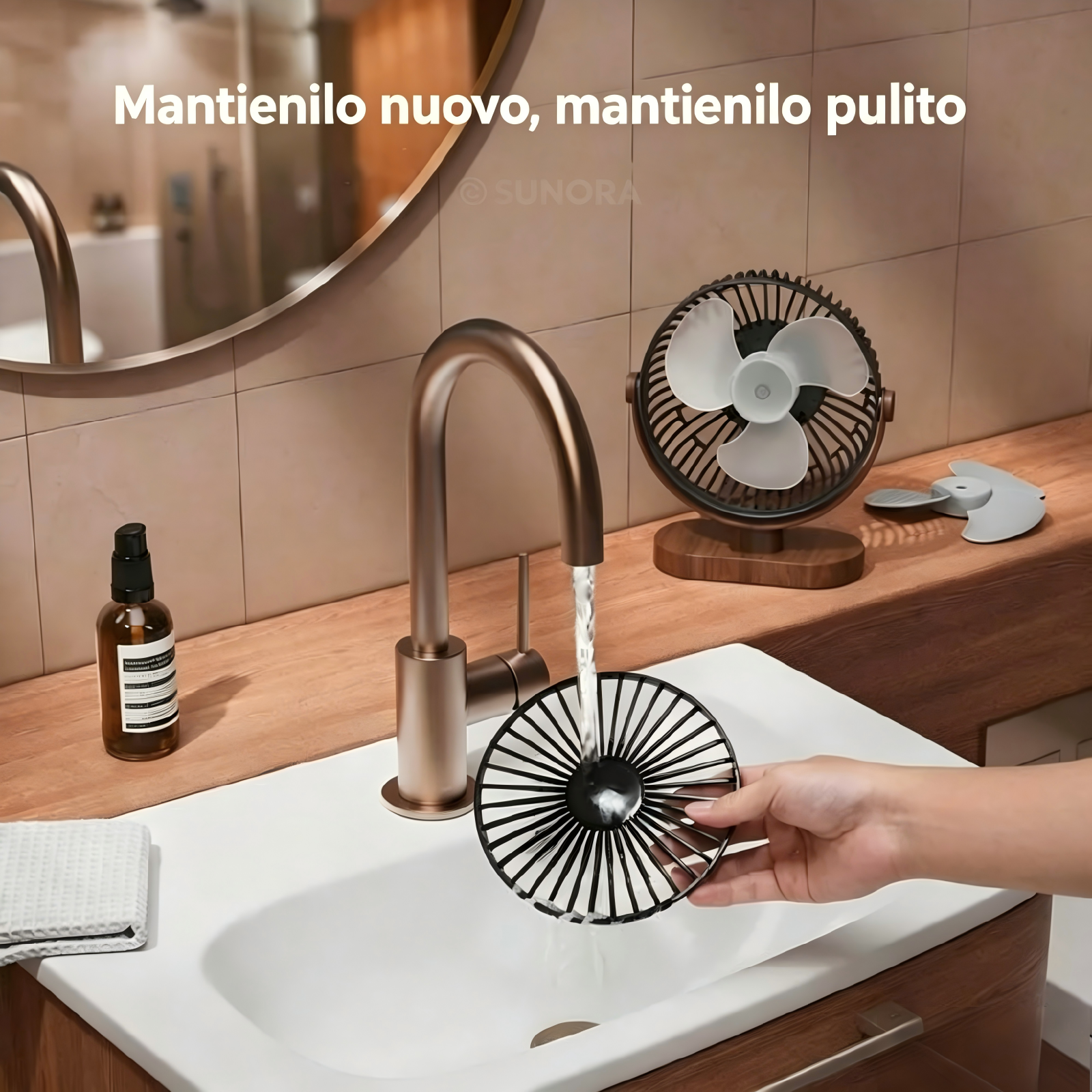 Lavaggio a mano della griglia di un ventilatore sotto acqua corrente in un lavandino.