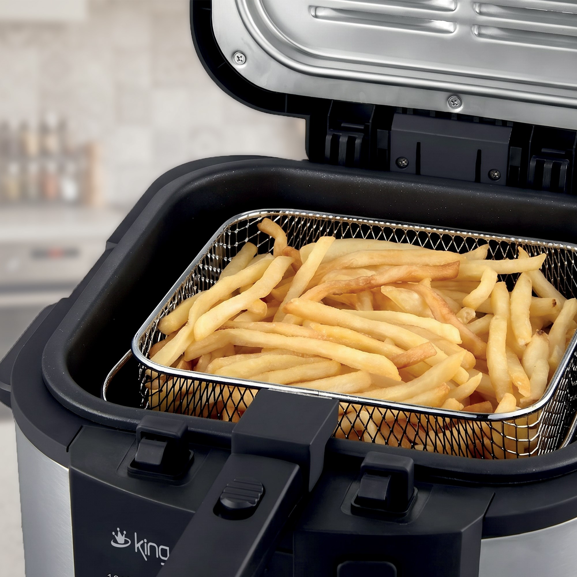 Altın rengi patates kızartması dolu metal sepet açık bir fritözün içinde.