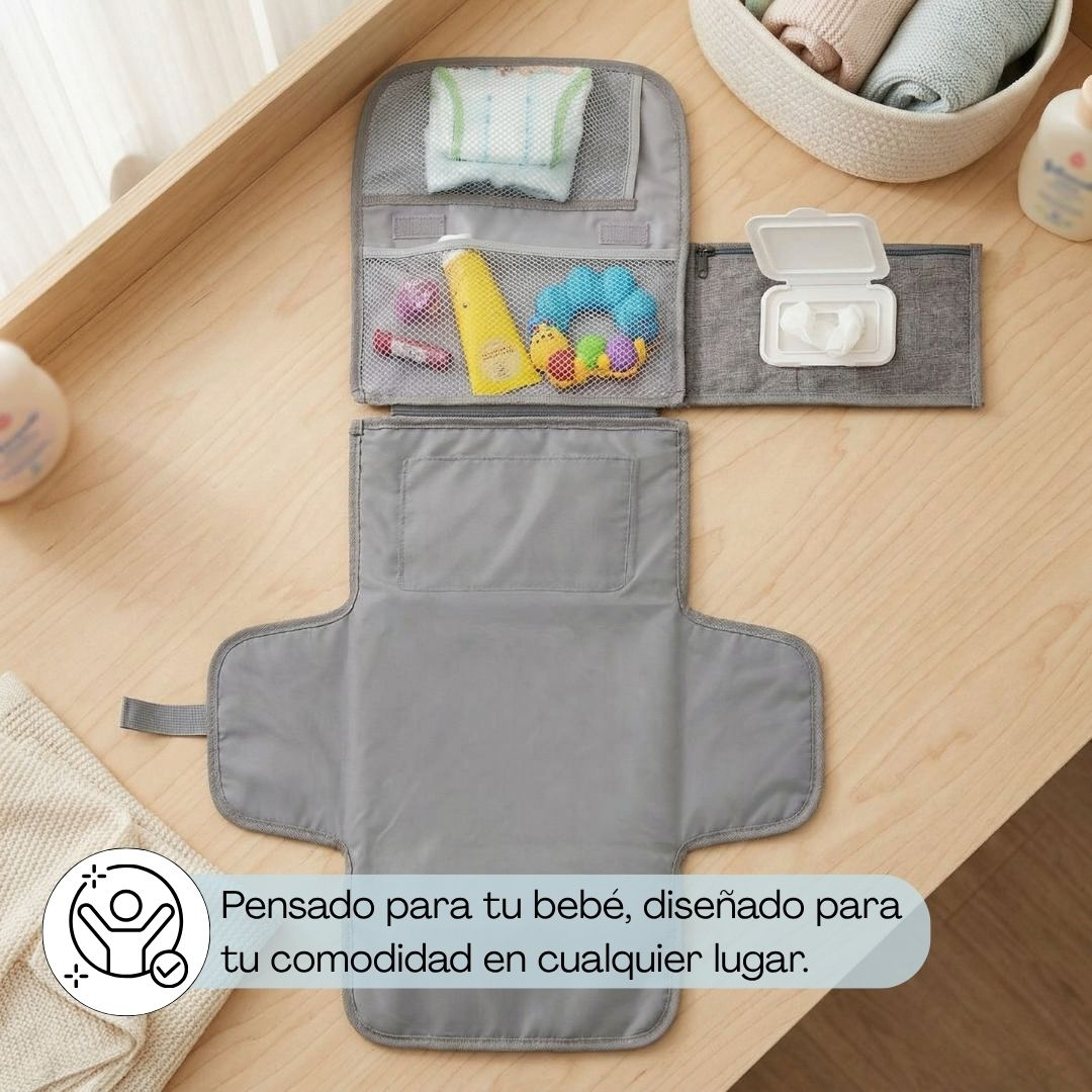 Organizador de pañales gris con pañales, crema, juguetes y toallitas en mesa madera.