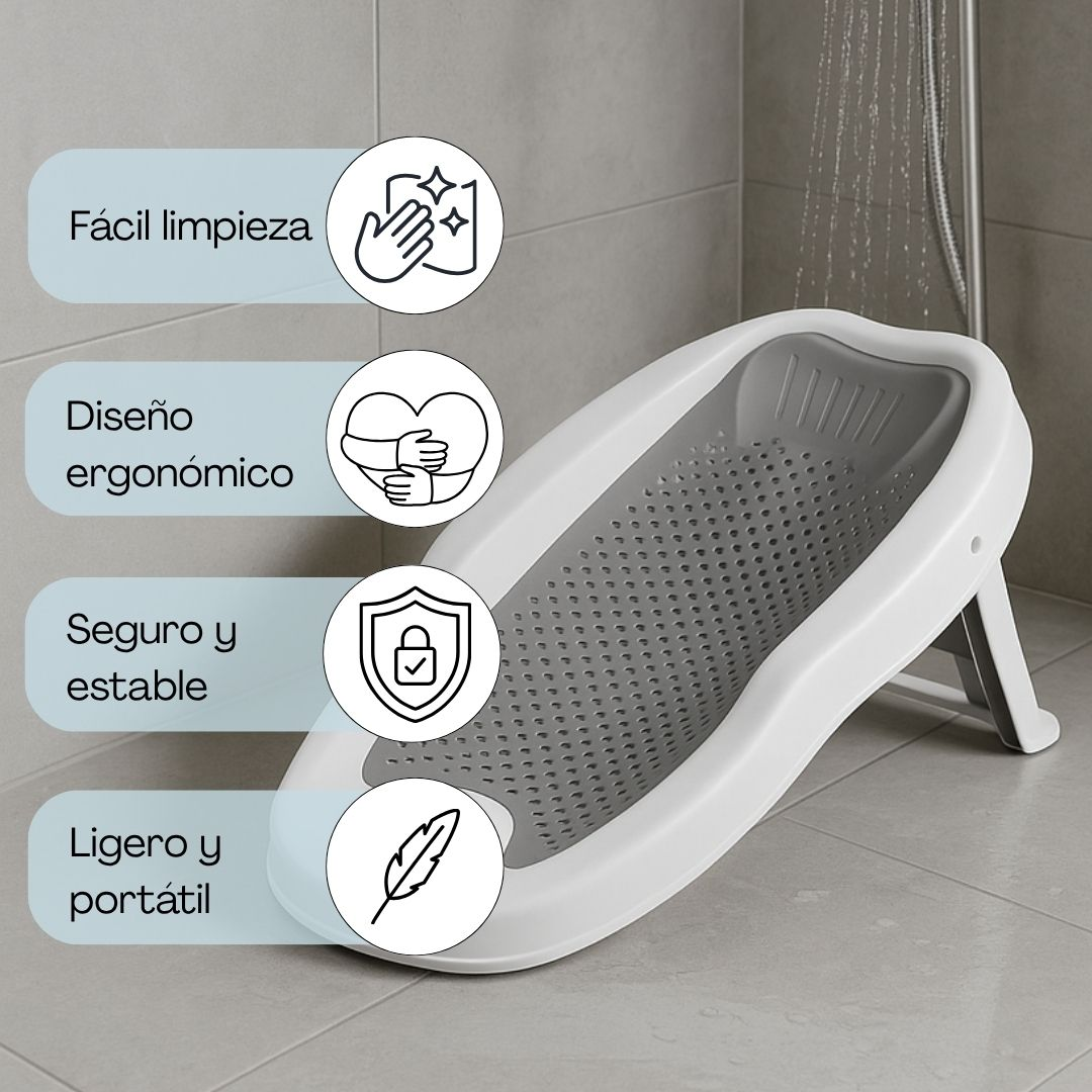 Un asiento blanco de soporte para bañera de bebé con asiento gris perforado está en el suelo de ducha.