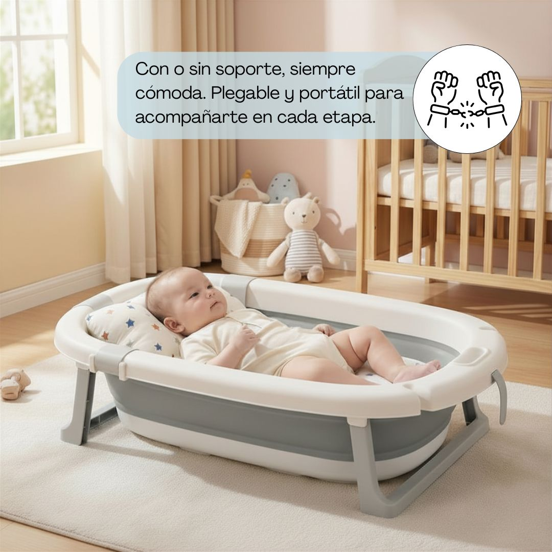 Un bebé yace en una bañera plegable gris y blanca sobre una alfombra.