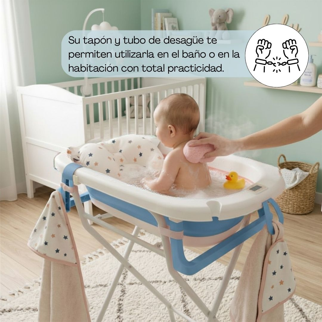 Un bebé se baña en una tina plegable mientras una mano lo lava. Un patito de goma flota cerca.