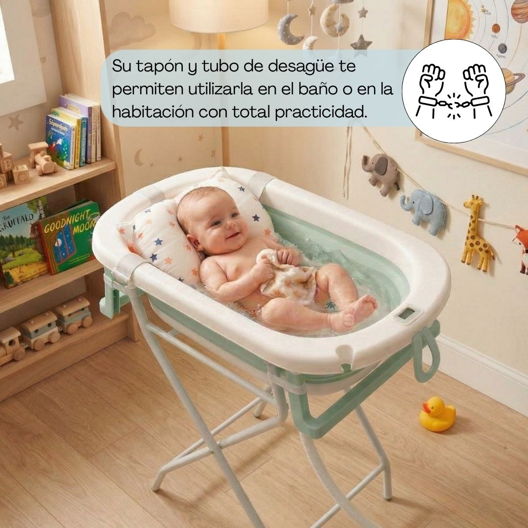 Un bebé en una bañera de bebé plegable sobre un soporte, con juguetes al fondo.