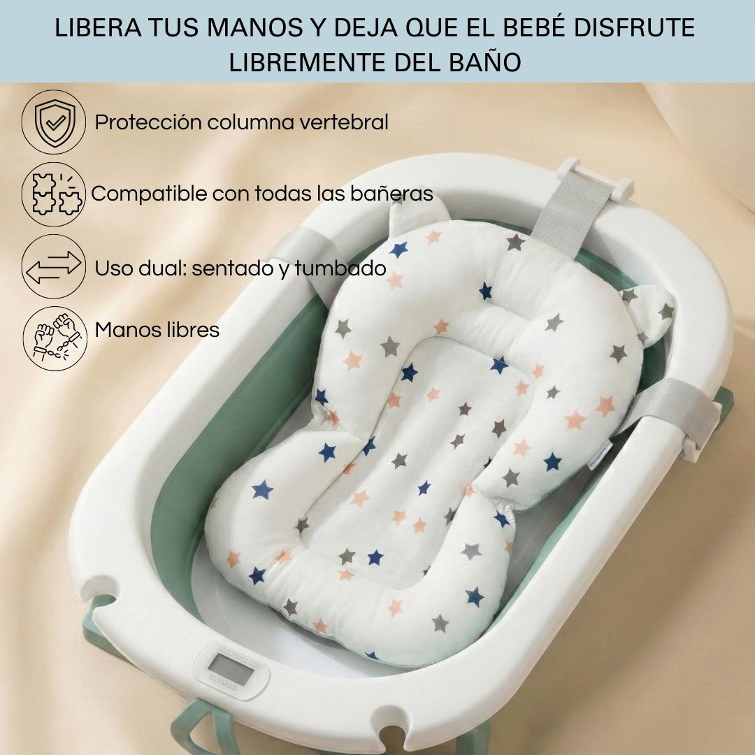 Un cojín blanco para baño de bebé con estrellas en una bañera de bebé verde y blanca.