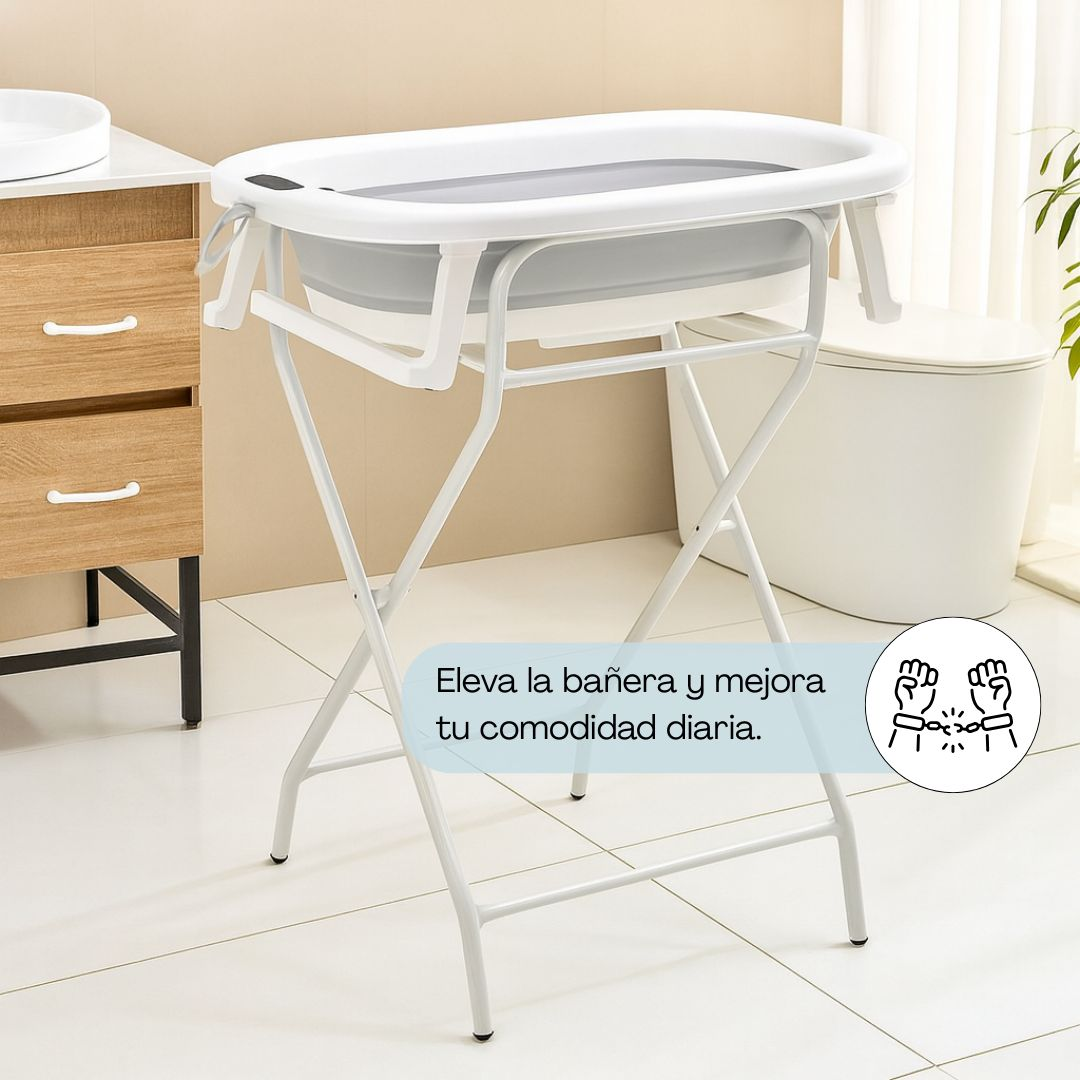 Un set de bañera blanca para bebé con soporte en un baño, junto a un inodoro y armario.