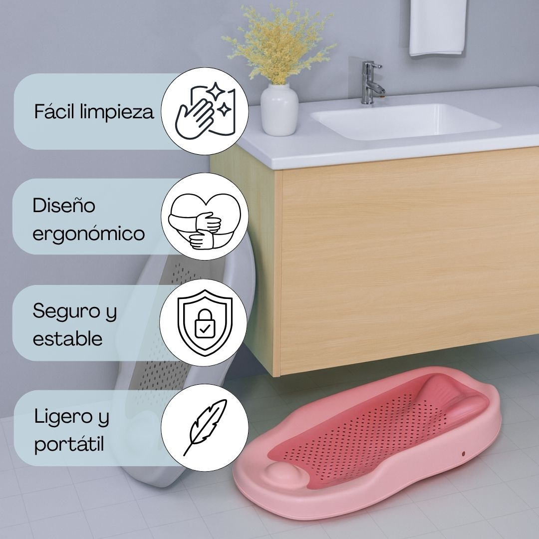 Asiento de baño rosa para bebé en suelo de baldosas junto a lavabo.