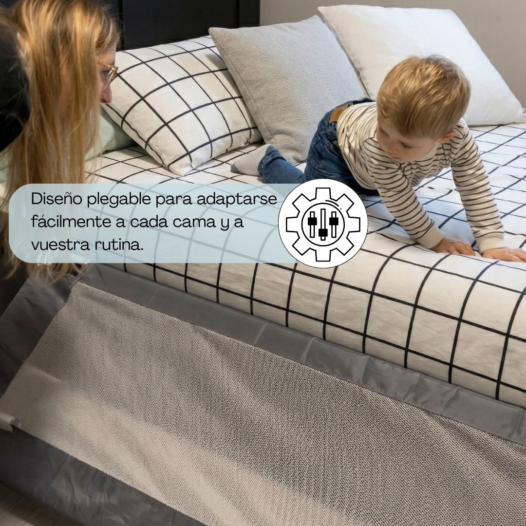Un niño gatea sobre una cama con ropa de cama a cuadros, una mujer observa.