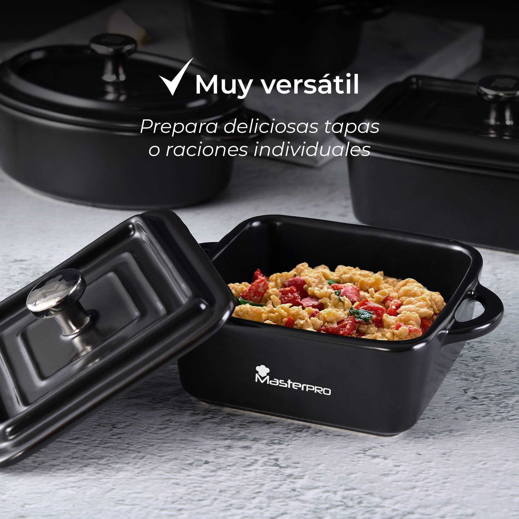 Cazuela negra con comida, tapa abierta. Varias cazuelas al fondo.